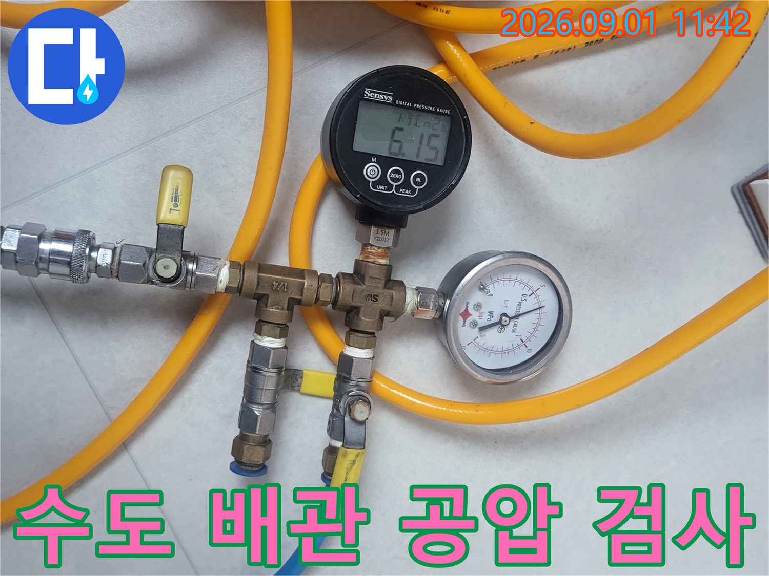 노란색 호스와 연결된 수도 배관 압력 측정 장치