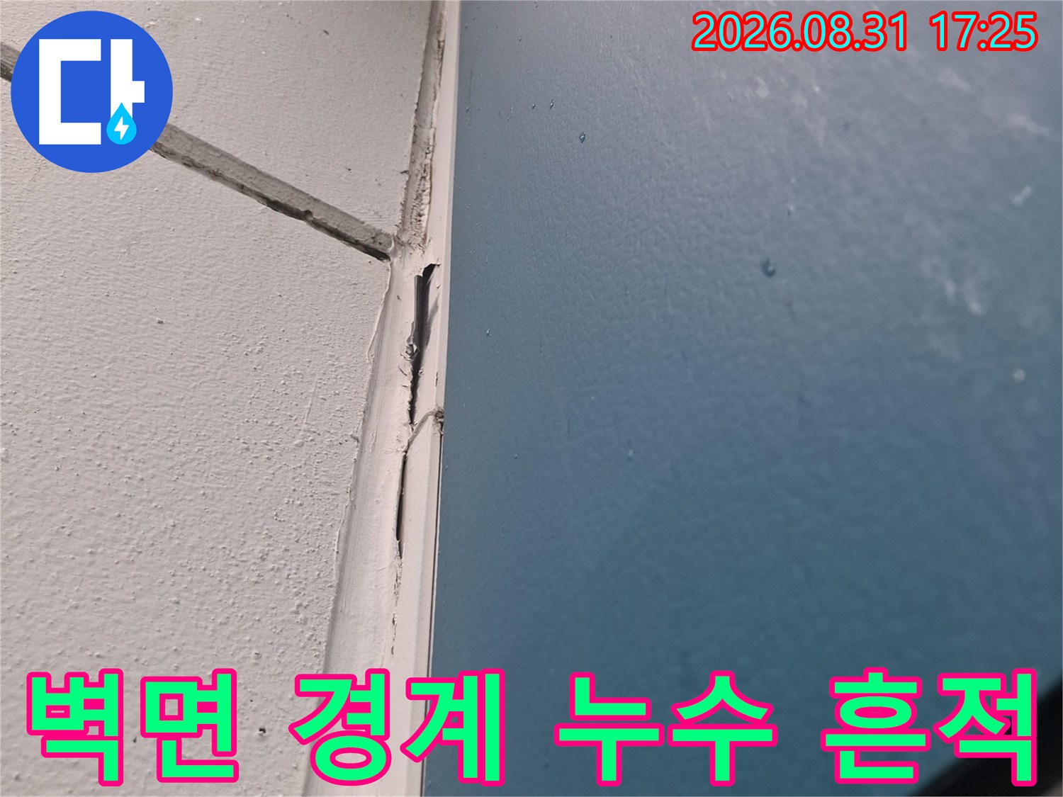 천장과 벽의 접합부 근처에 나타난 어두운 얼룩과 습기