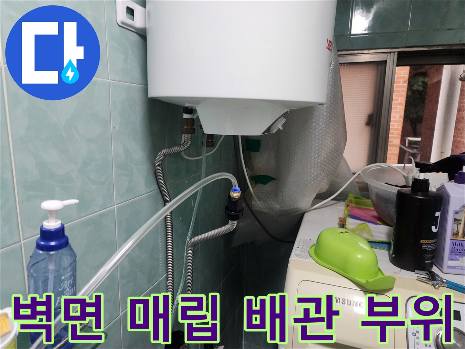 벽면 타일 사이로 연결된 은색 보온재 배관의 모습