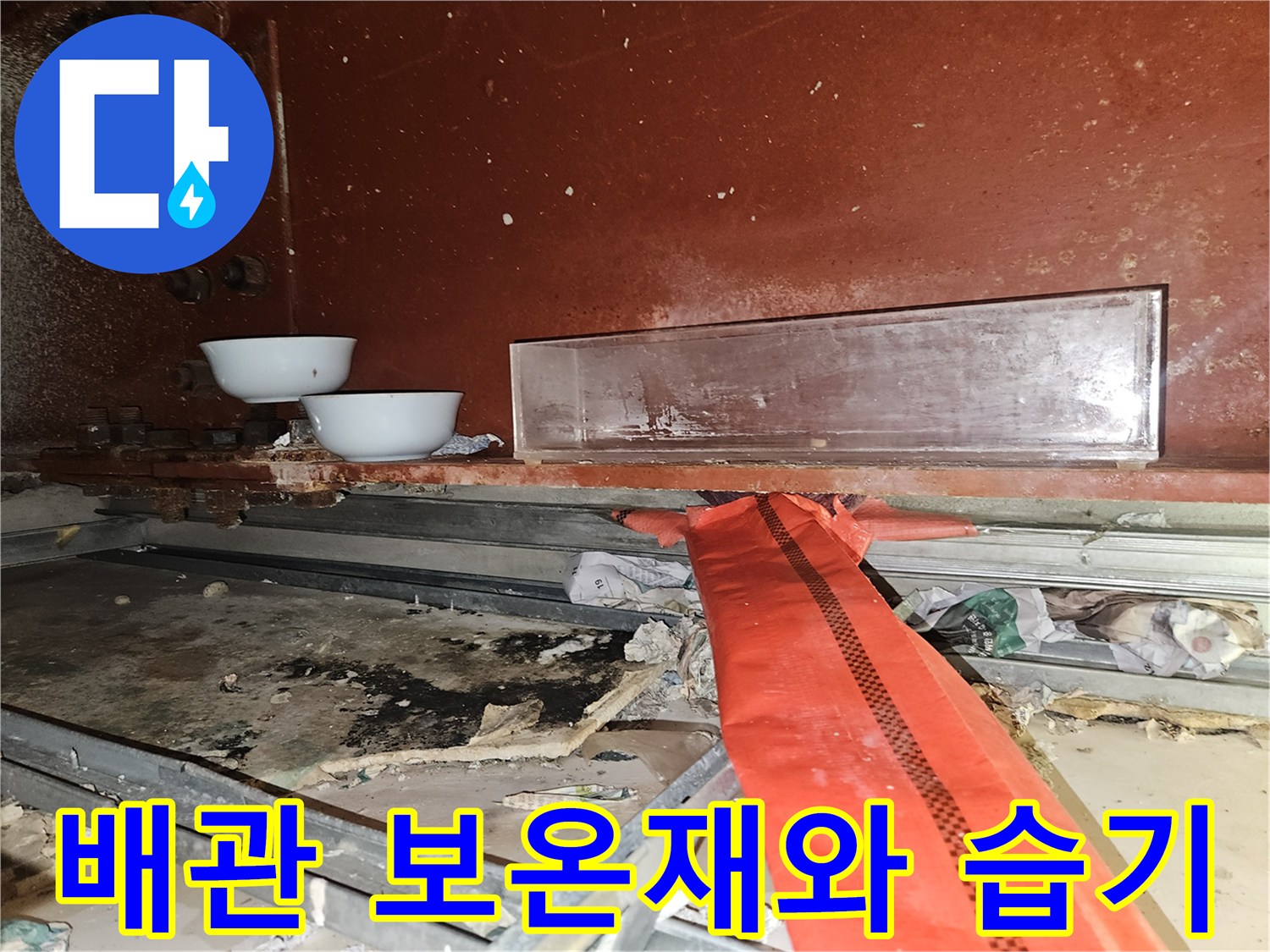 붉은색 보온재로 감싸진 배관 주변의 습한 환경