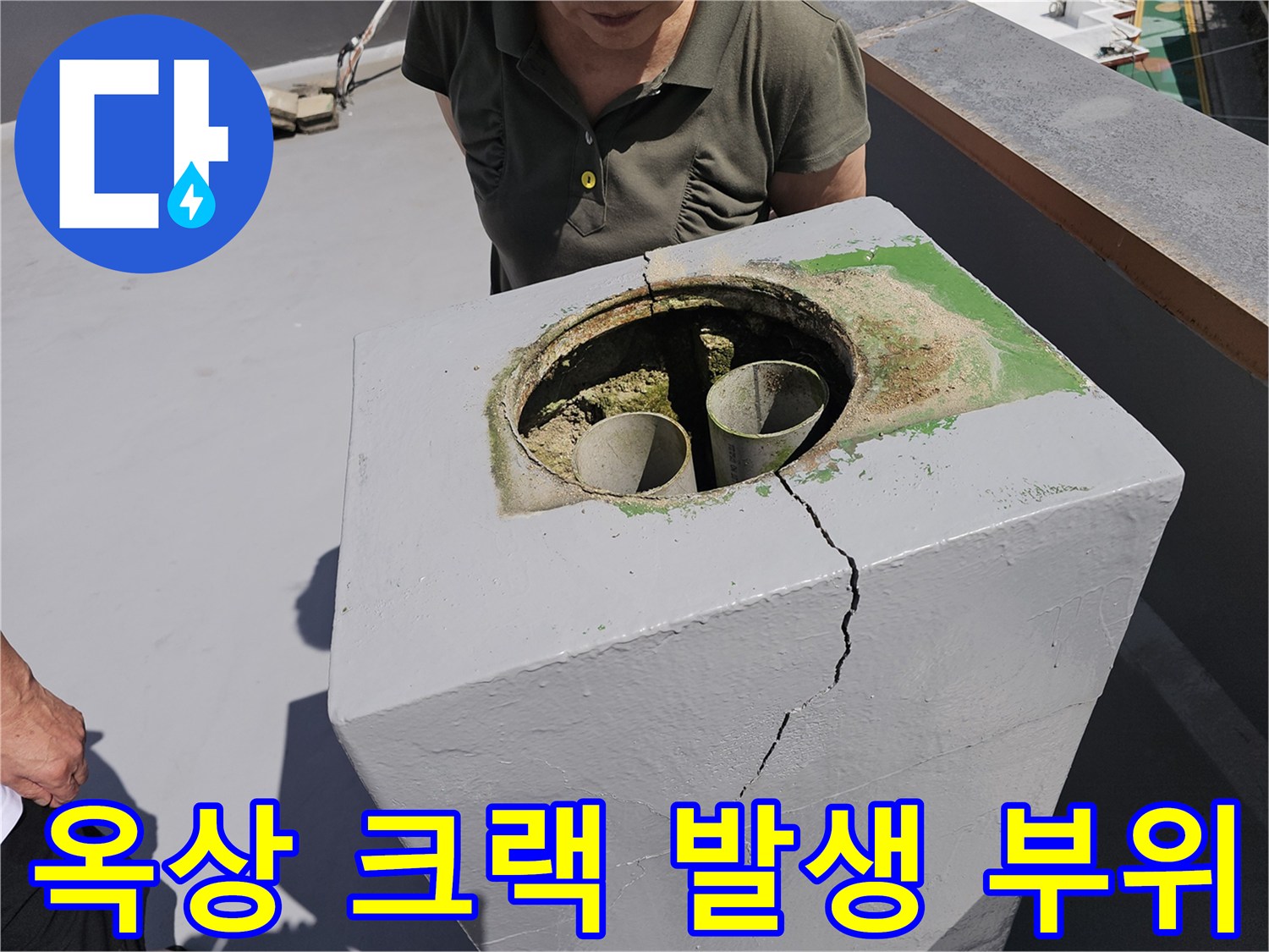 배수관 주변 콘크리트의 수직 균열과 습기 흔적