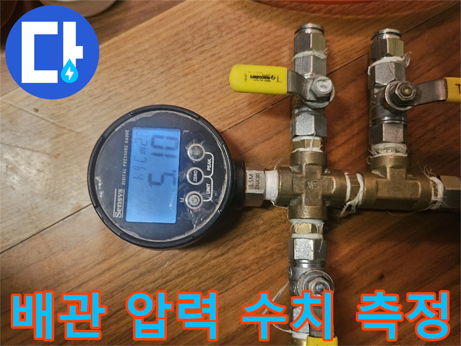 배관 연결 부위와 디지털 압력계가 결합된 점검 장비의 모습