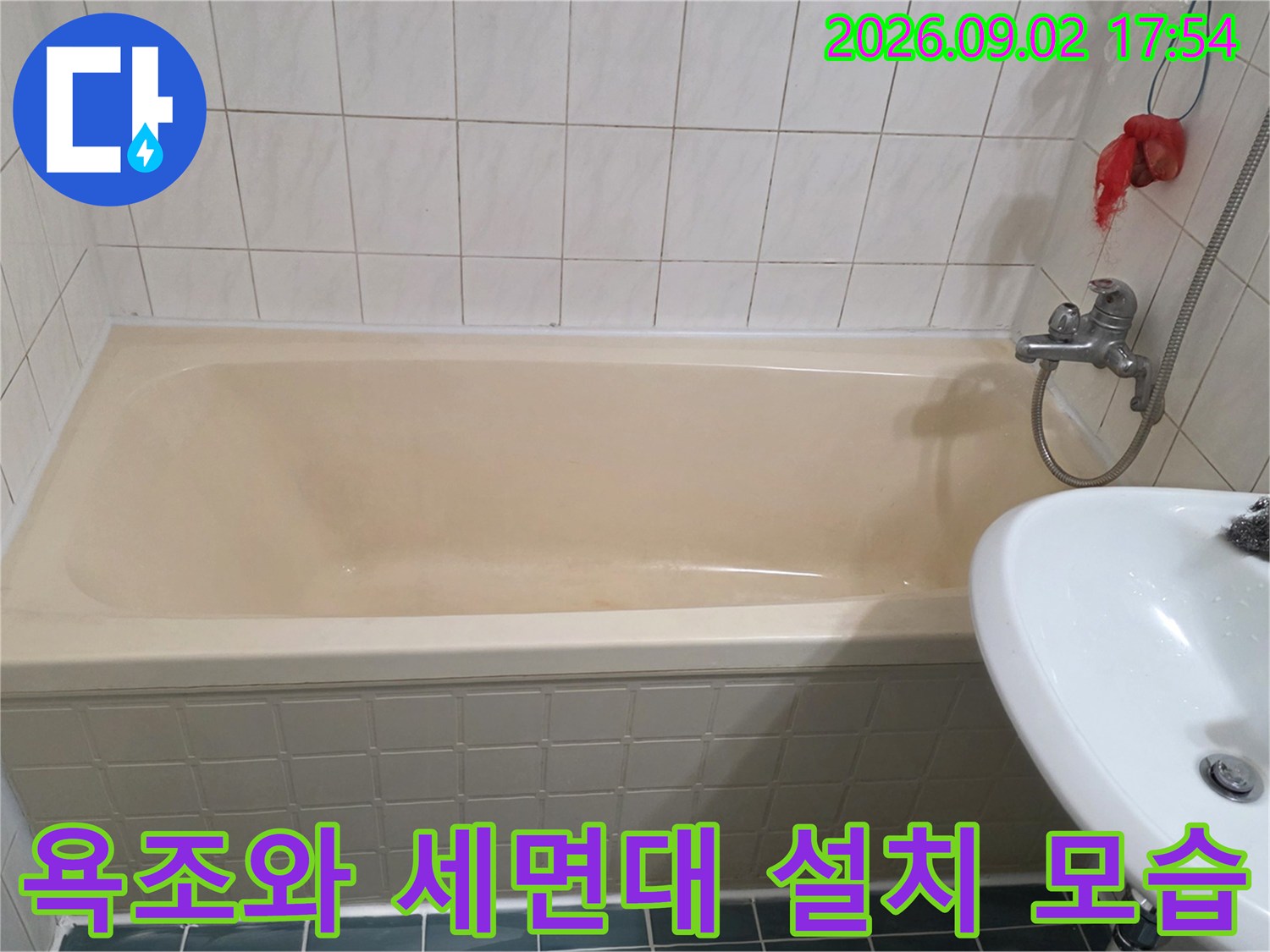 화장실 벽면에 설치된 수전과 베이지색 욕조의 모습입니다.