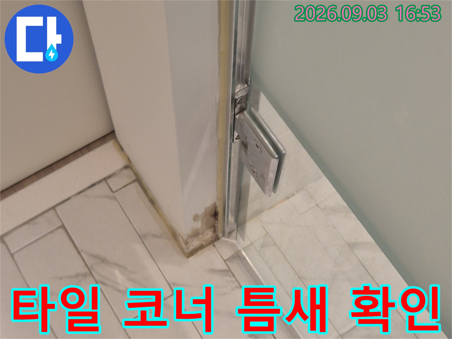 하얀색 대리석 패턴 타일의 모서리 마감 상태를 촬영한 사진입니다