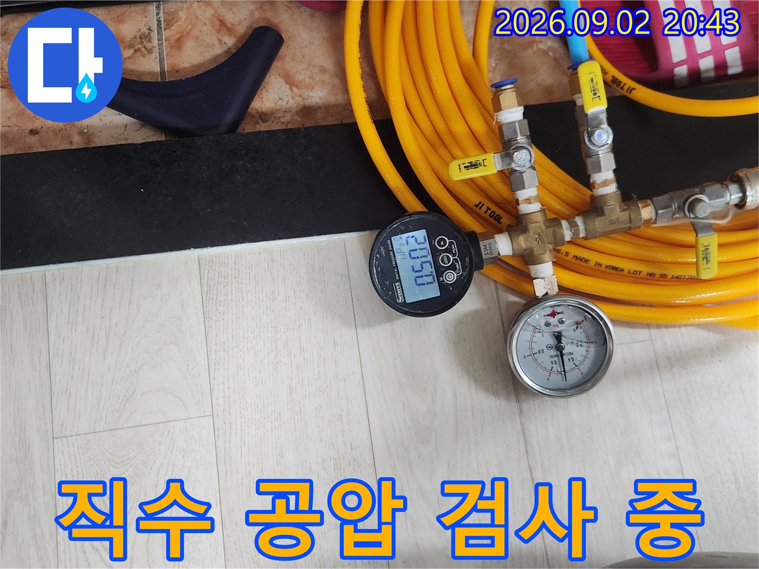 노란색 호스와 압력 게이지를 활용한-직수 배관 공압 테스트 진행 중