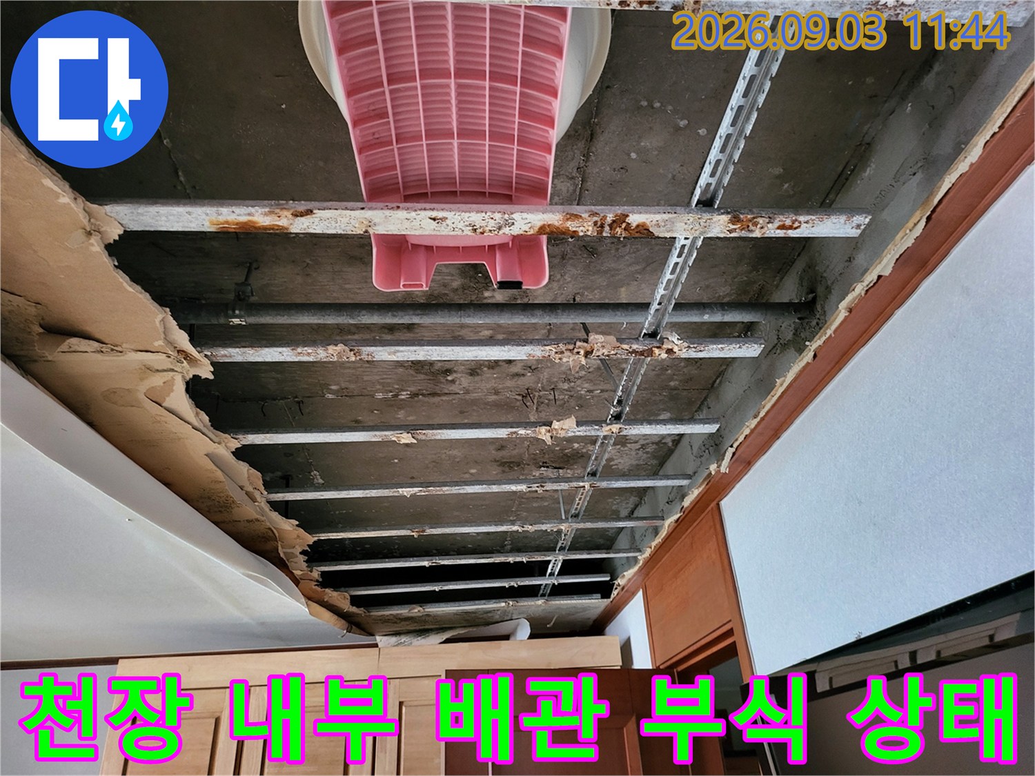 누수가 진행된 장안동 아파트-천장 내부의 금속 지지대와 콘크리트 슬래브 상태를 보여줍니다.