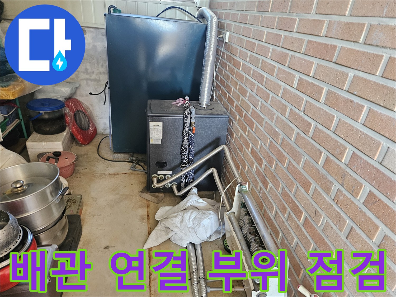 금속 배관과 보일러 하부의 복잡한 연결 구조를 보여주는 사진입니다.