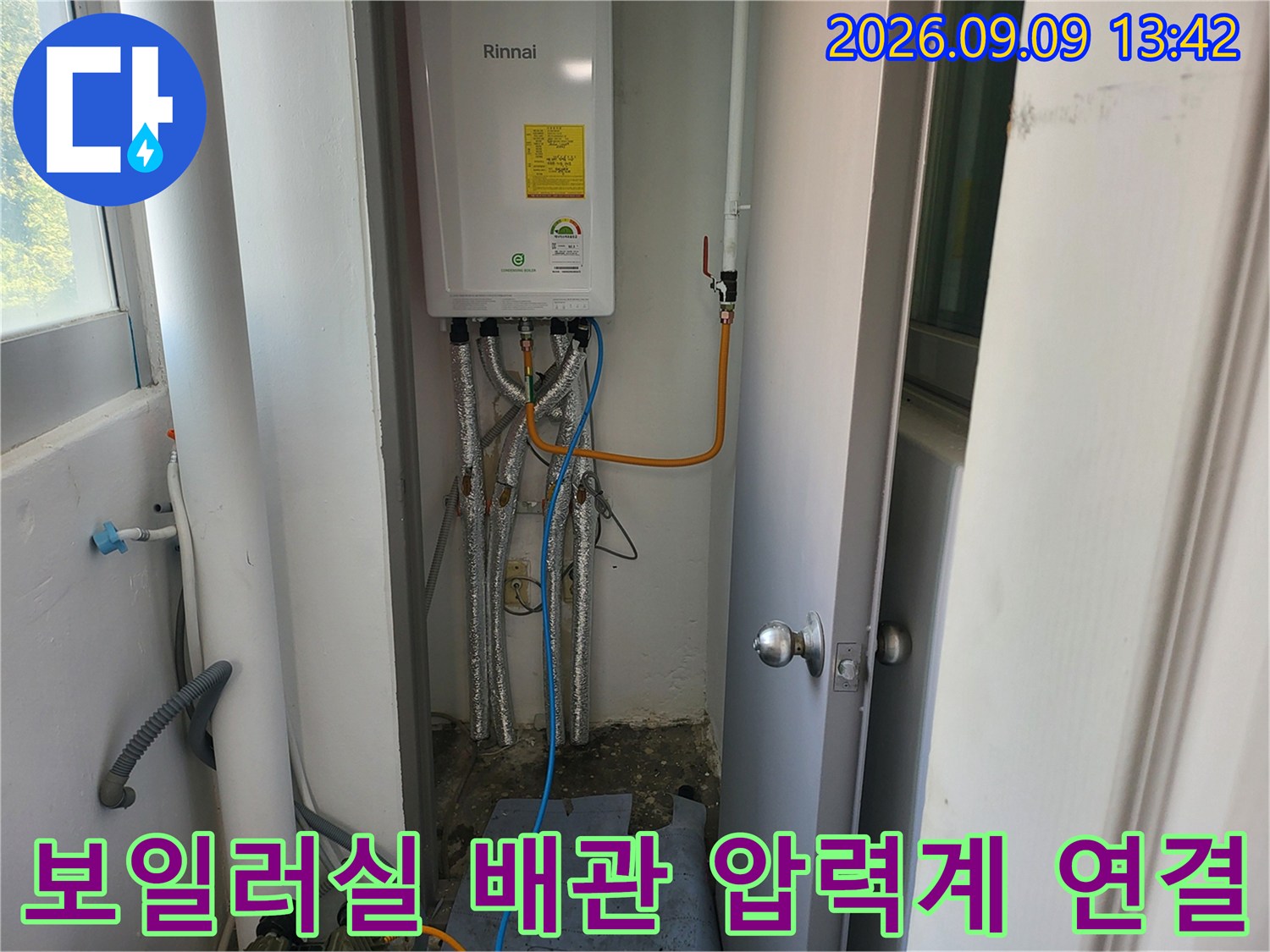 보일러 하단 배관에 파란색 호스와 압력계를 연결하여 누수를 점검합니다.