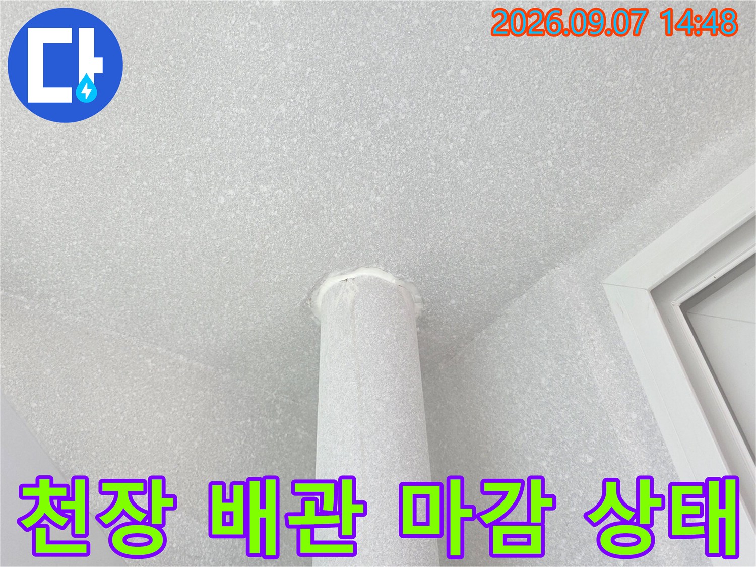 하얀색 천장과 수직으로 내려오는 우수관의 모습입니다.