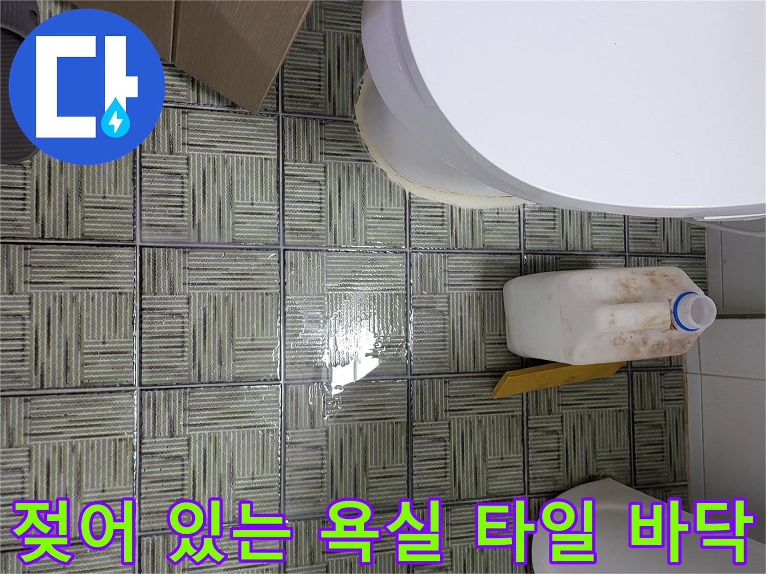 물기가 스며든 화장실 타일과 배수구 주변의 모습 - 누수 원인 조사 중