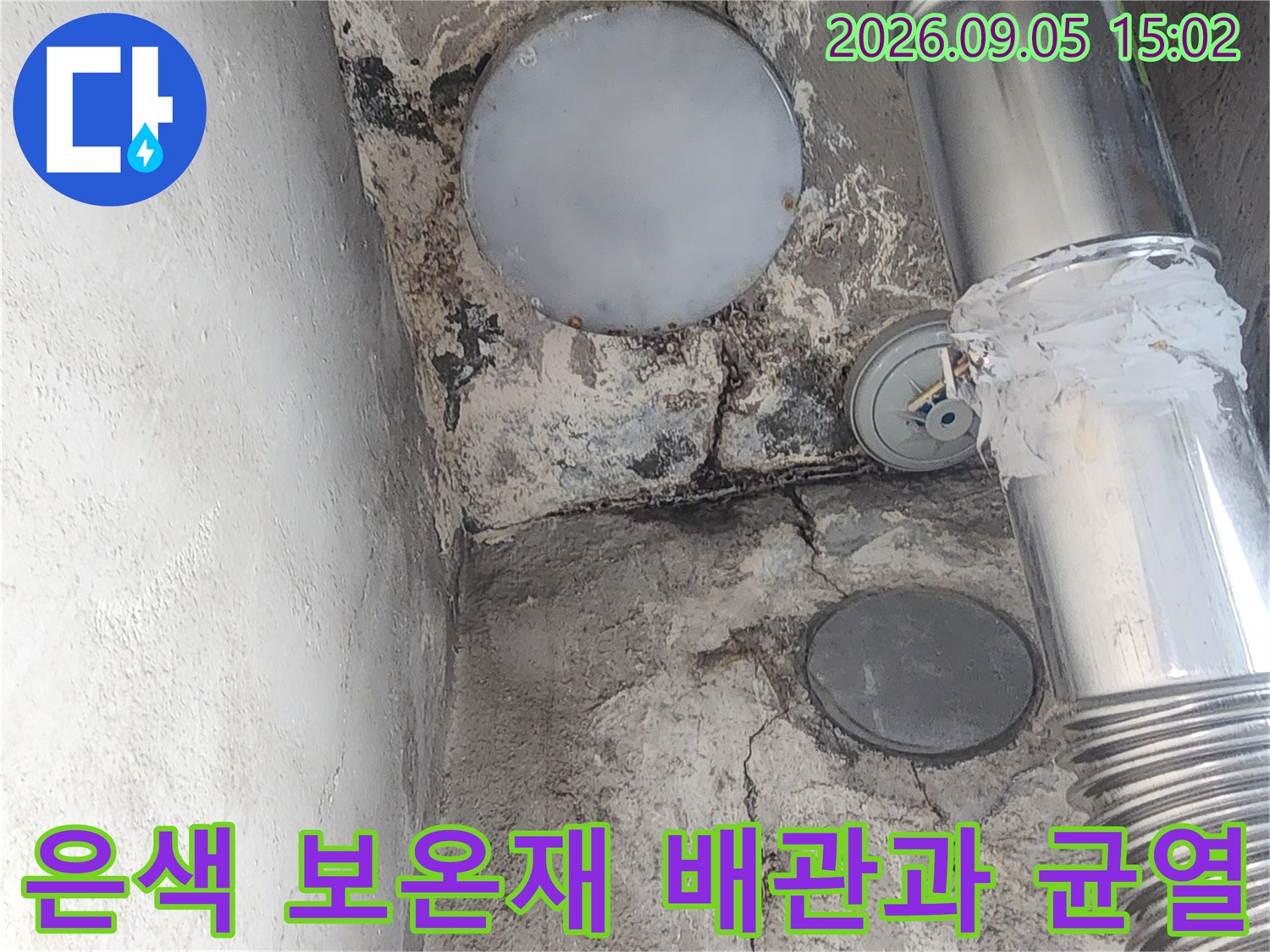 벽면의 갈라진 틈과 은색 배관 연결 부위 근접 촬영