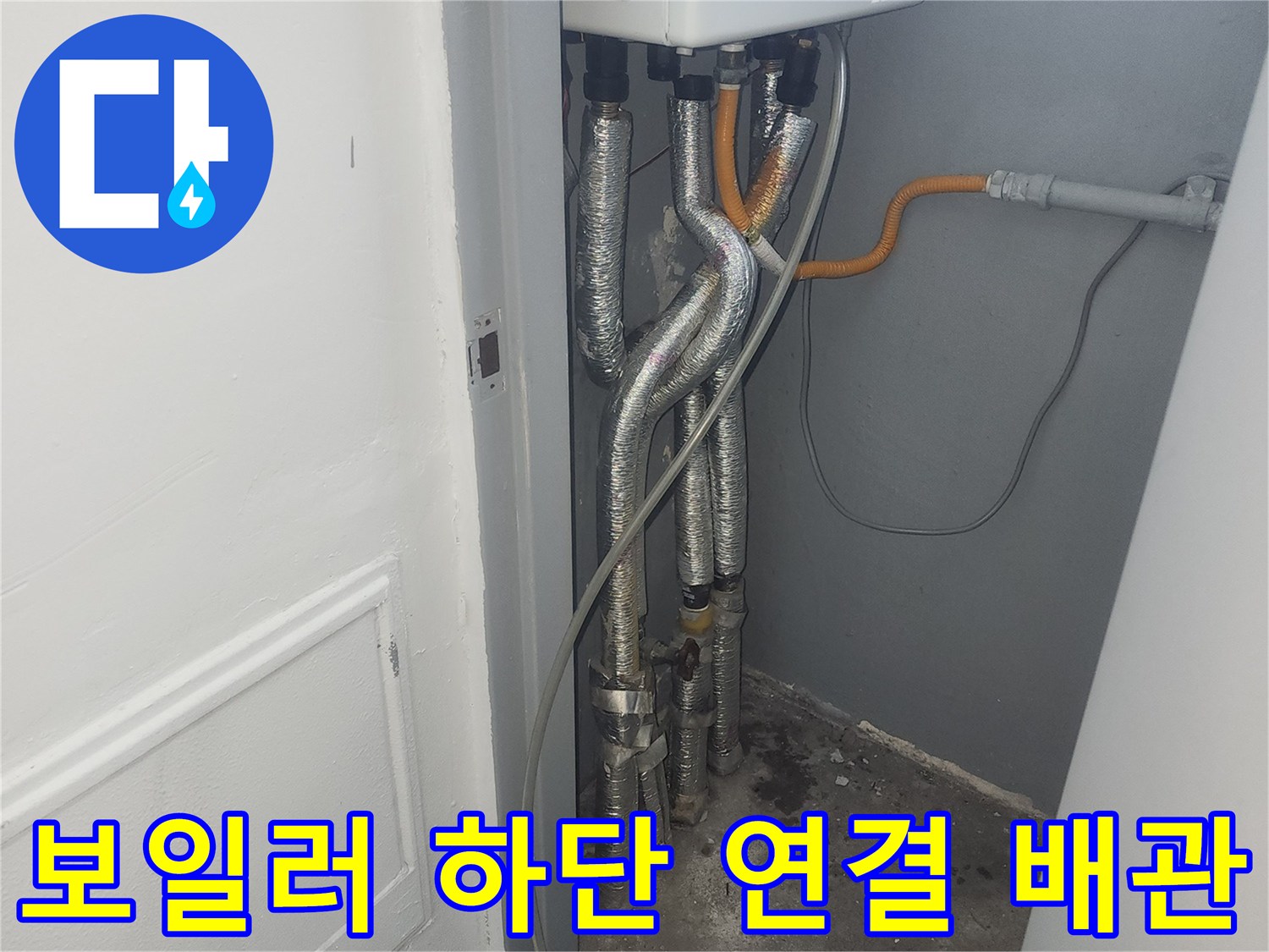 보일러 본체 아래의 은색 호스와 노란색 가스 배관 모습
