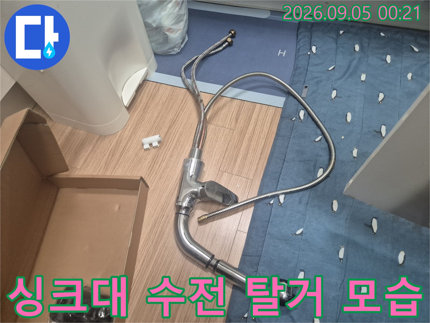 싱크대 아래 작업 공간에 놓인 탈거된 수전 부품