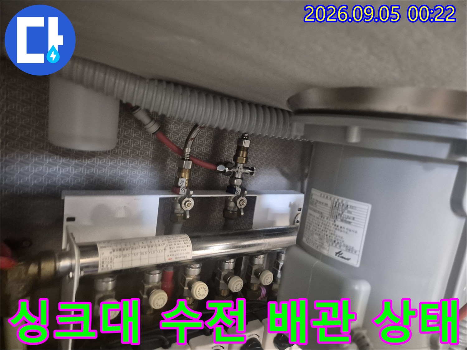 싱크대 아래쪽 급수 밸브와 새로 교체된 수전 호스를 촬영한 사진입니다.