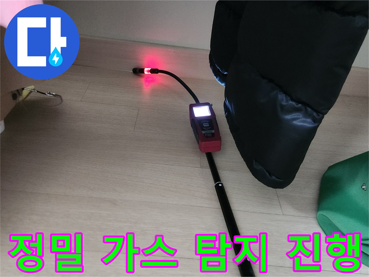 붉은색 표시등이 켜진-가스 탐지기로 배관 누설 부위를 추적하는 장면