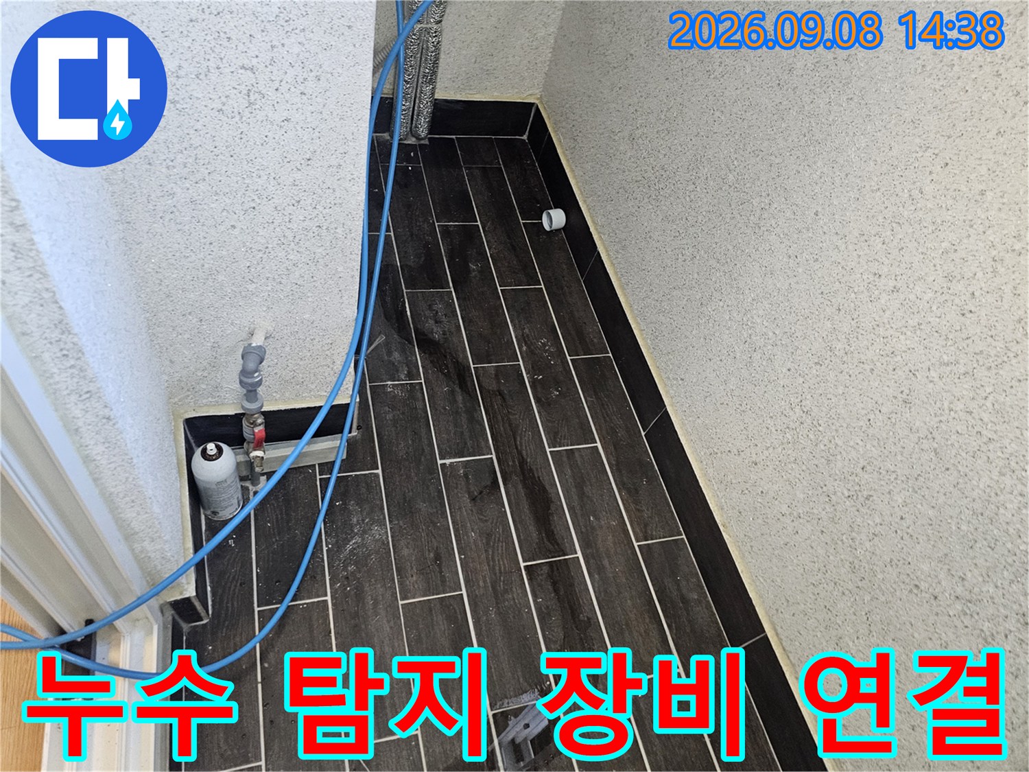 타일 벽면에 설치된 압력 게이지와 파란색 에어 호스 연결 상태