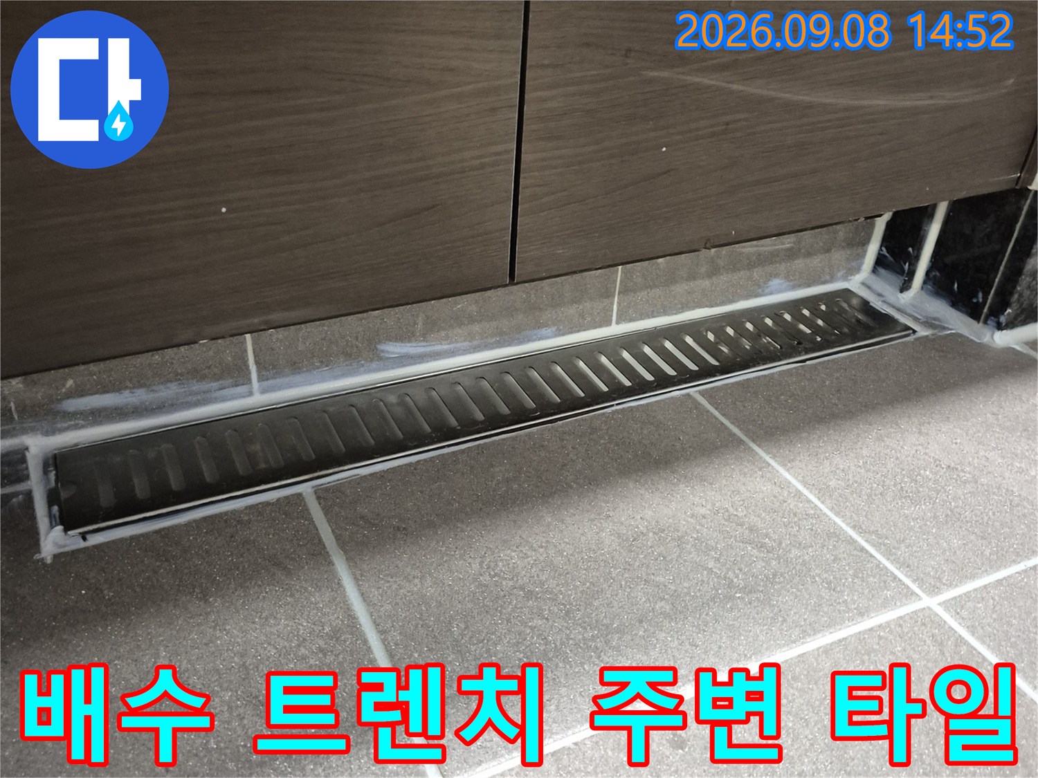 중앙동 욕실의 배수 트렌치와 바닥 타일 마감 부위 상세 사진입니다.