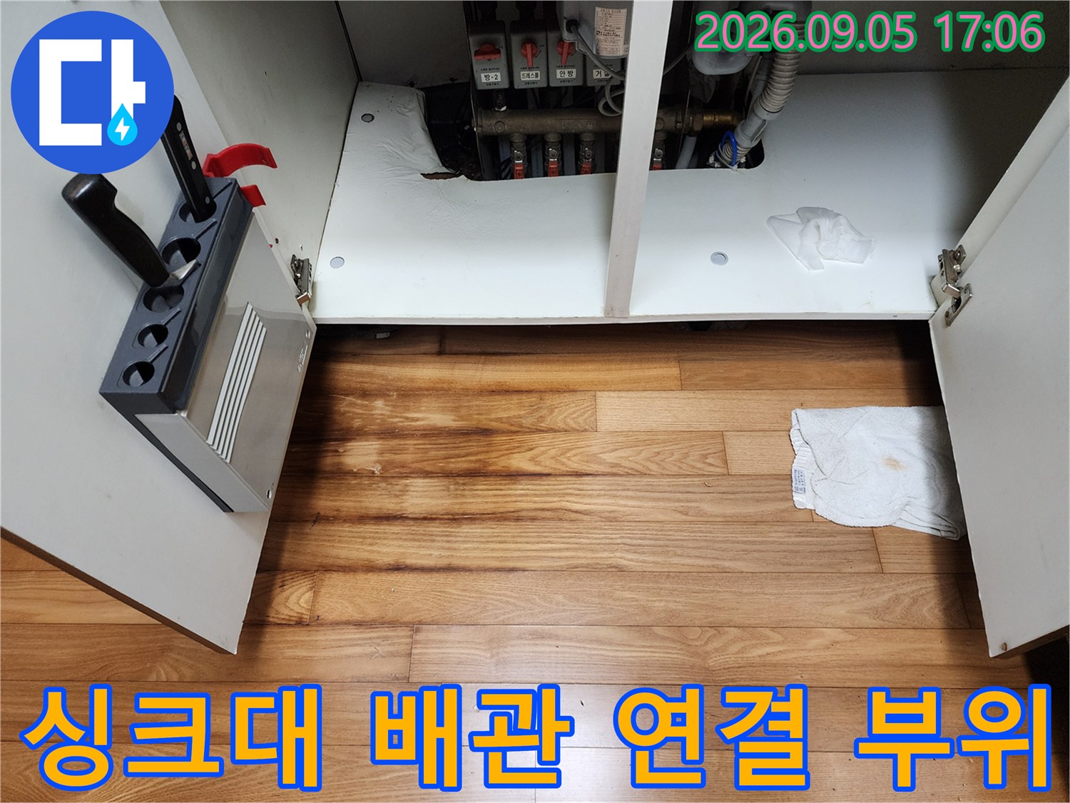 싱크대 하부장 내부에 노출된 급수 배관과 밸브들