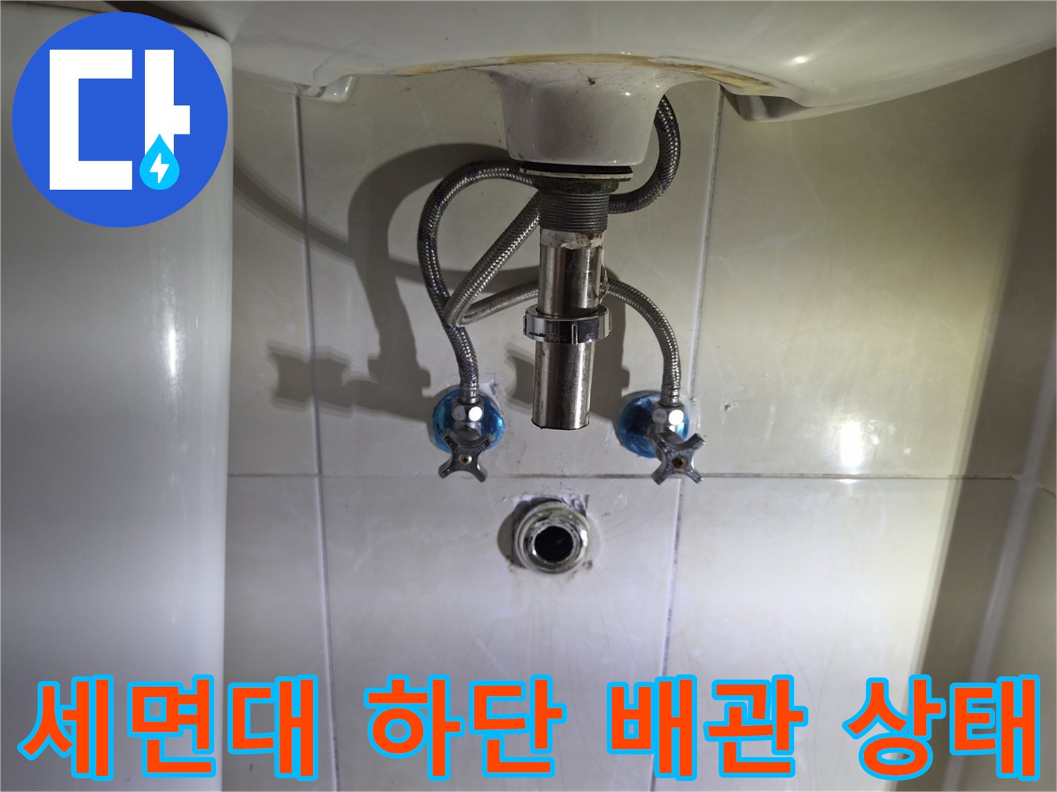 구로동 화장실 세면대 아래쪽 배관과 벽면 타일 연결 부위 모습