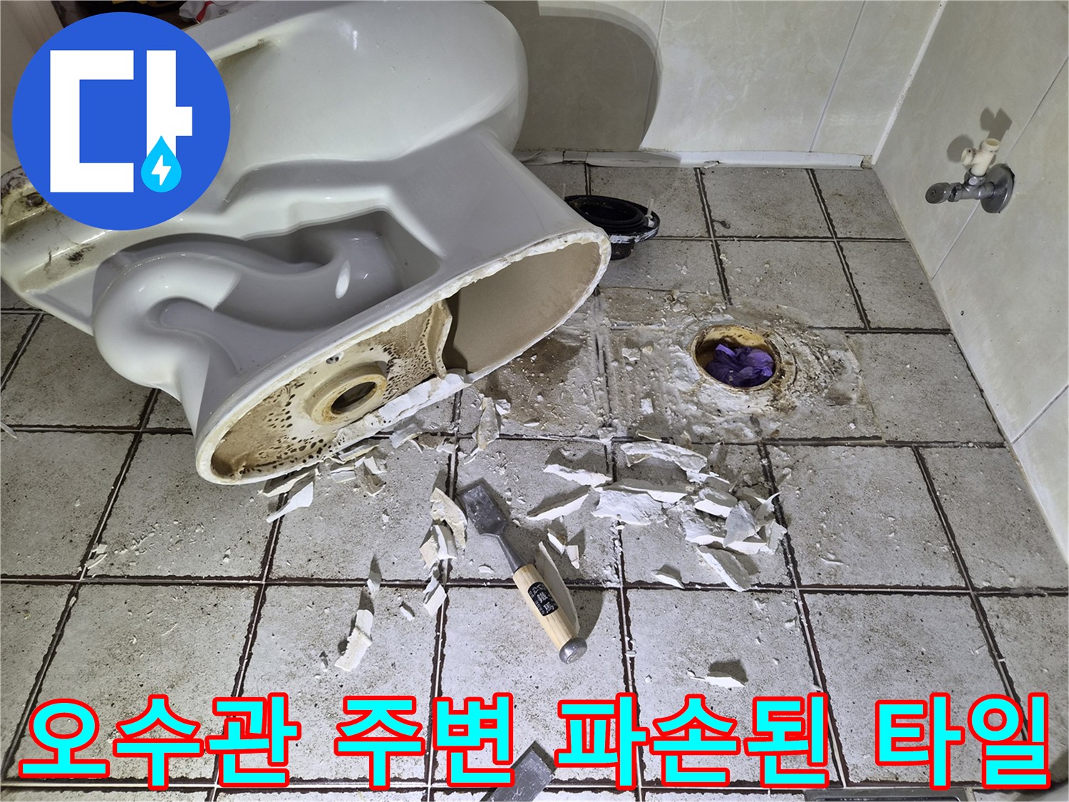 변기 하부 오수관 주변의 부서진 타일과 이물질이 섞인 바닥 모습