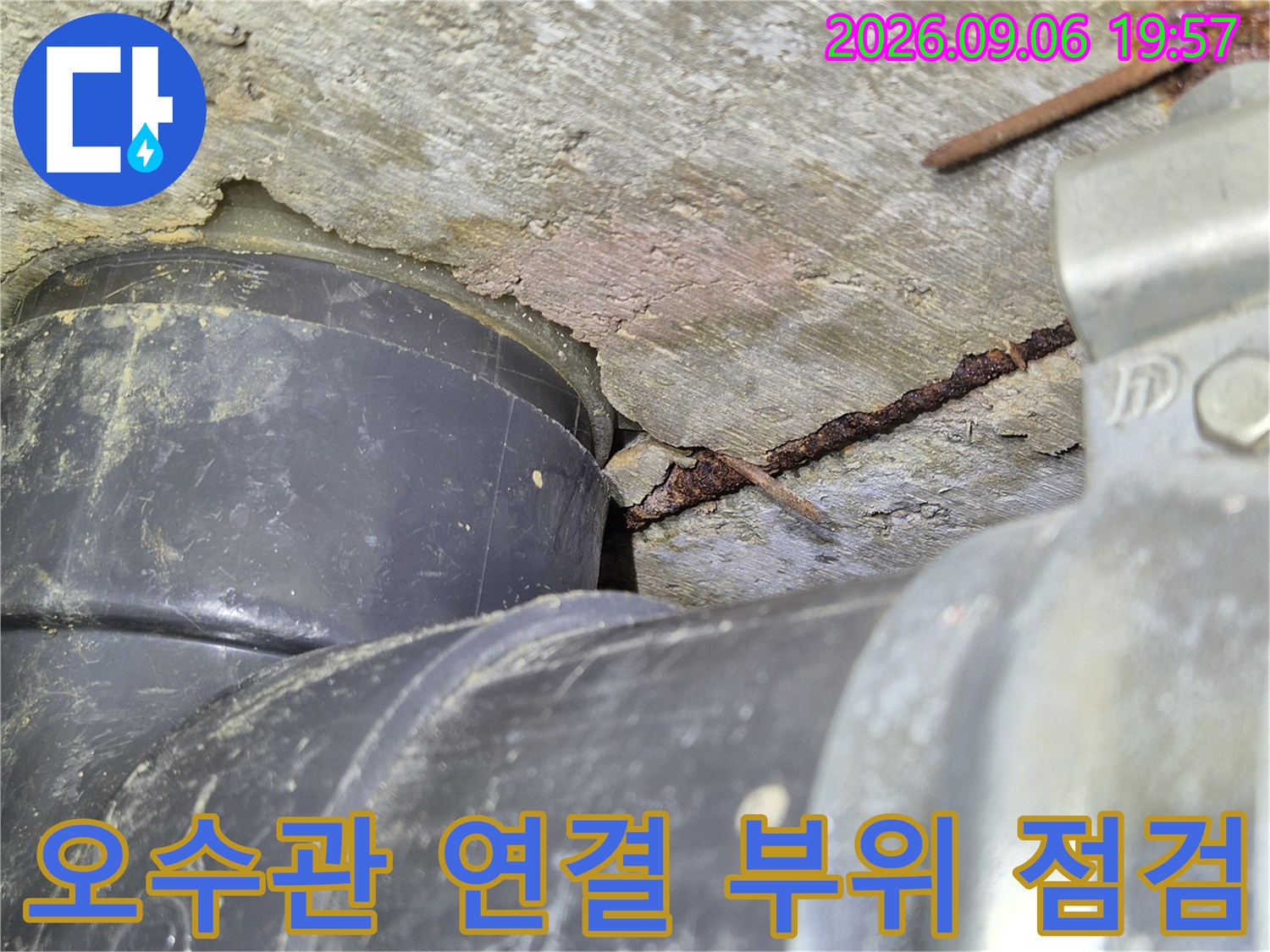 오수관과 천장 구조물 사이의 틈새를 근접 촬영한 이미지입니다.
