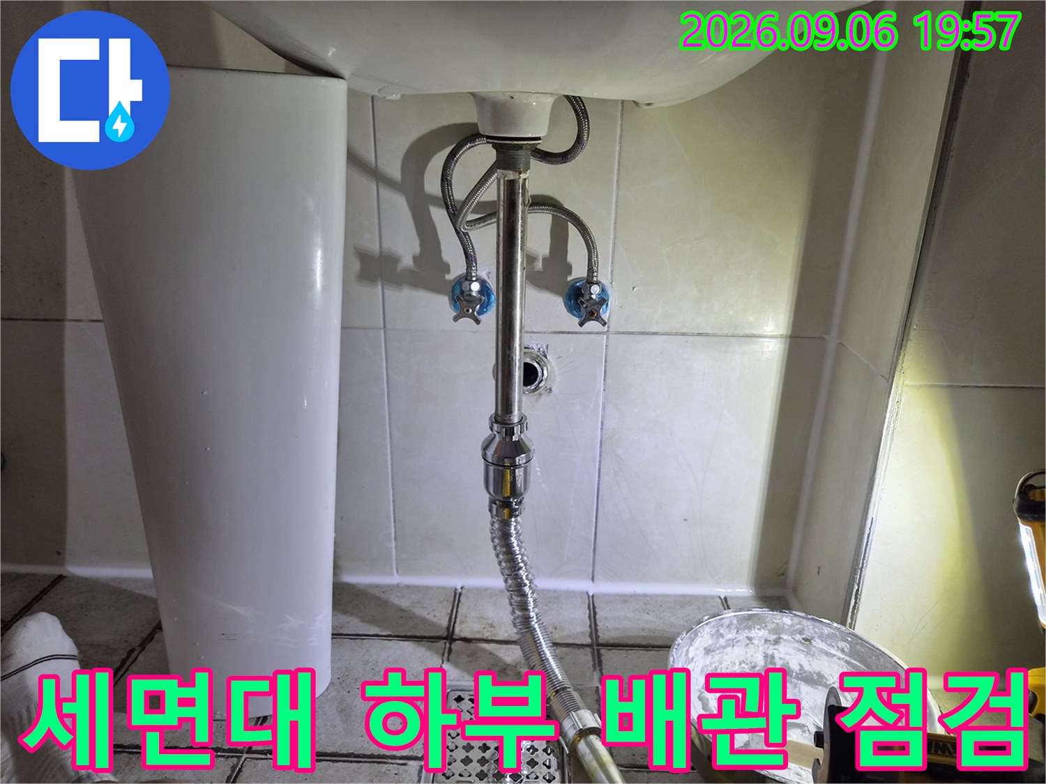 화장실 세면대 아래쪽 급수 밸브와 배수 호스 연결 부위 클로즈업