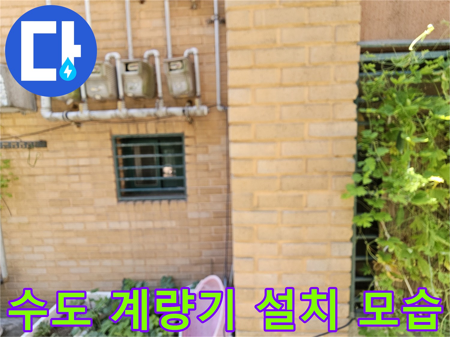 건물 외벽 벽돌 구조물에 부착된 수도 계량기 장치들입니다.
