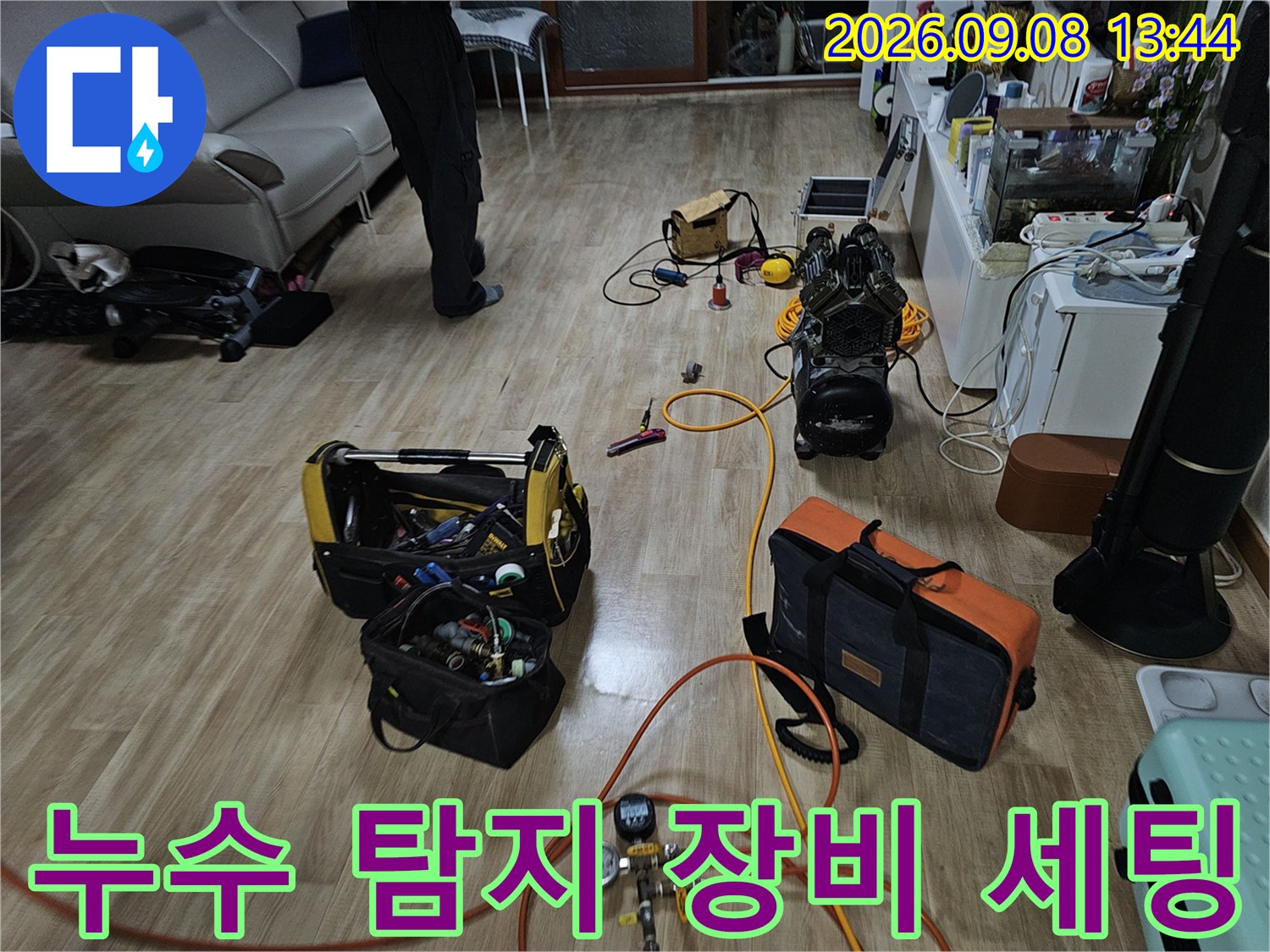 누수 지점을 찾기 위해 거실 바닥에 배치된 가스 탐지기와 압력계 장비들입니다.