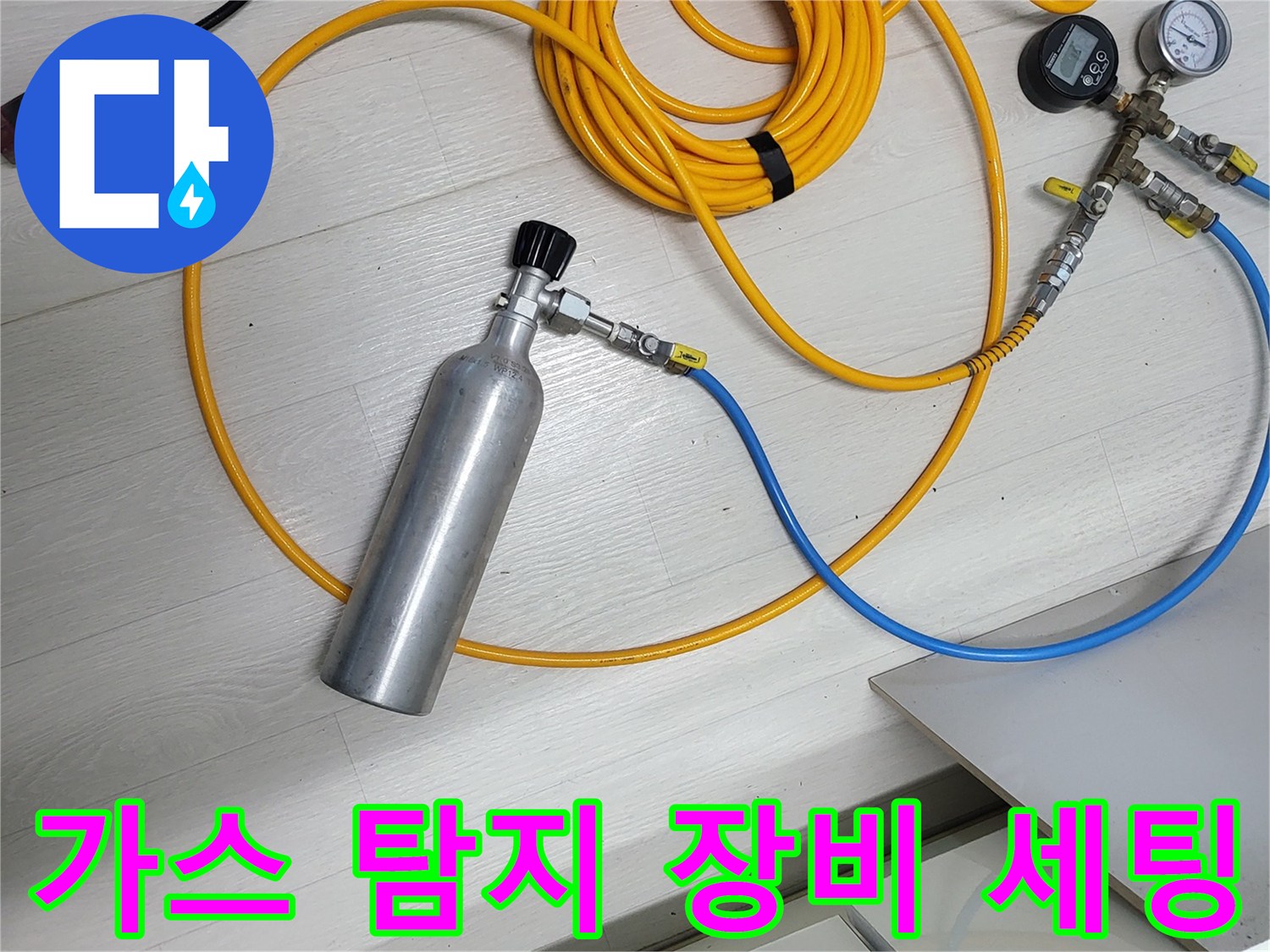 누수 지점을 찾기 위해 가스 압력을 이용한 정밀 탐지 장비를 준비하는 모습입니다.