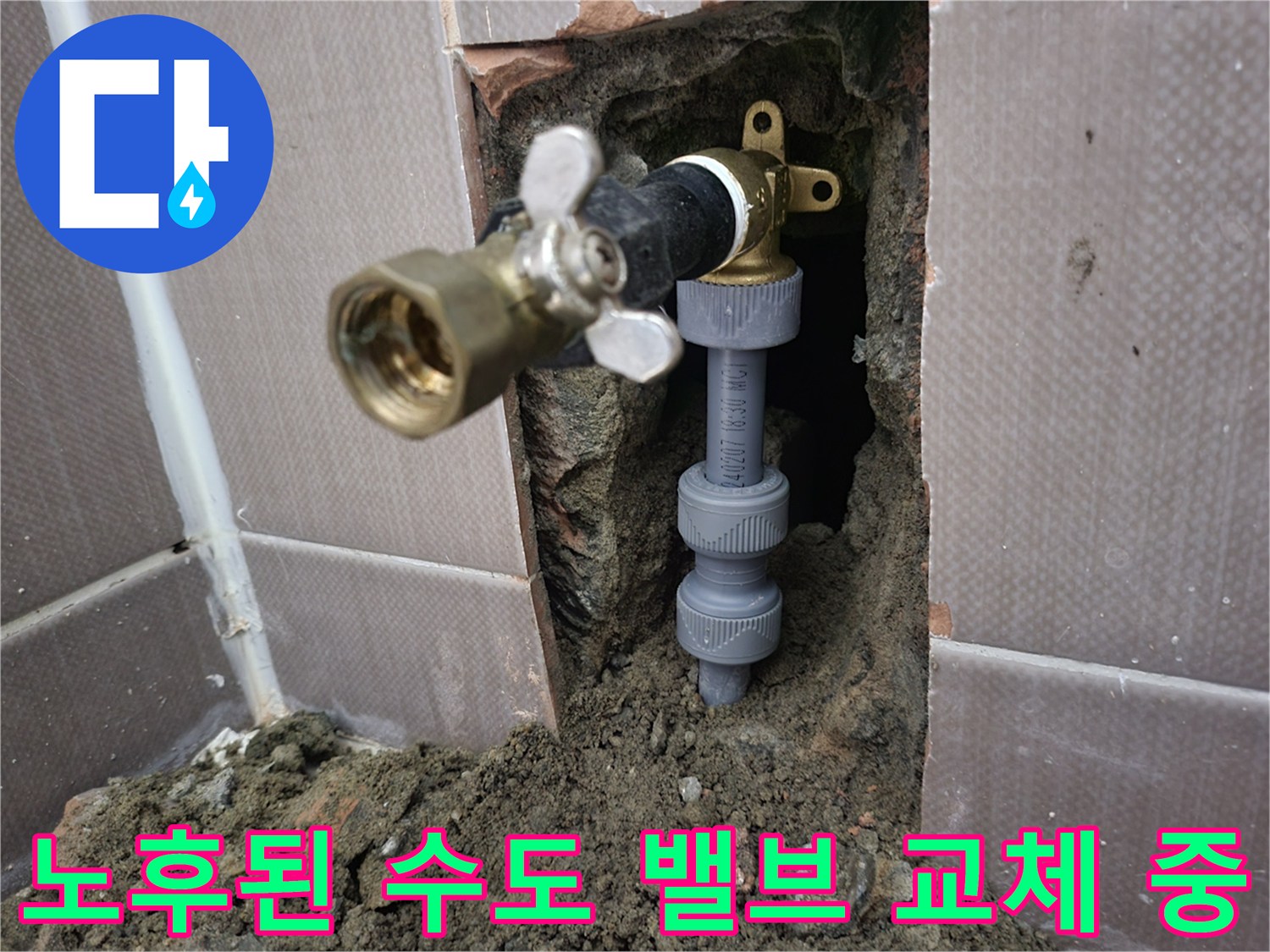 벽면 타일 파쇄 후 드러난 변기 급수용 금색 밸브와 회색 배관