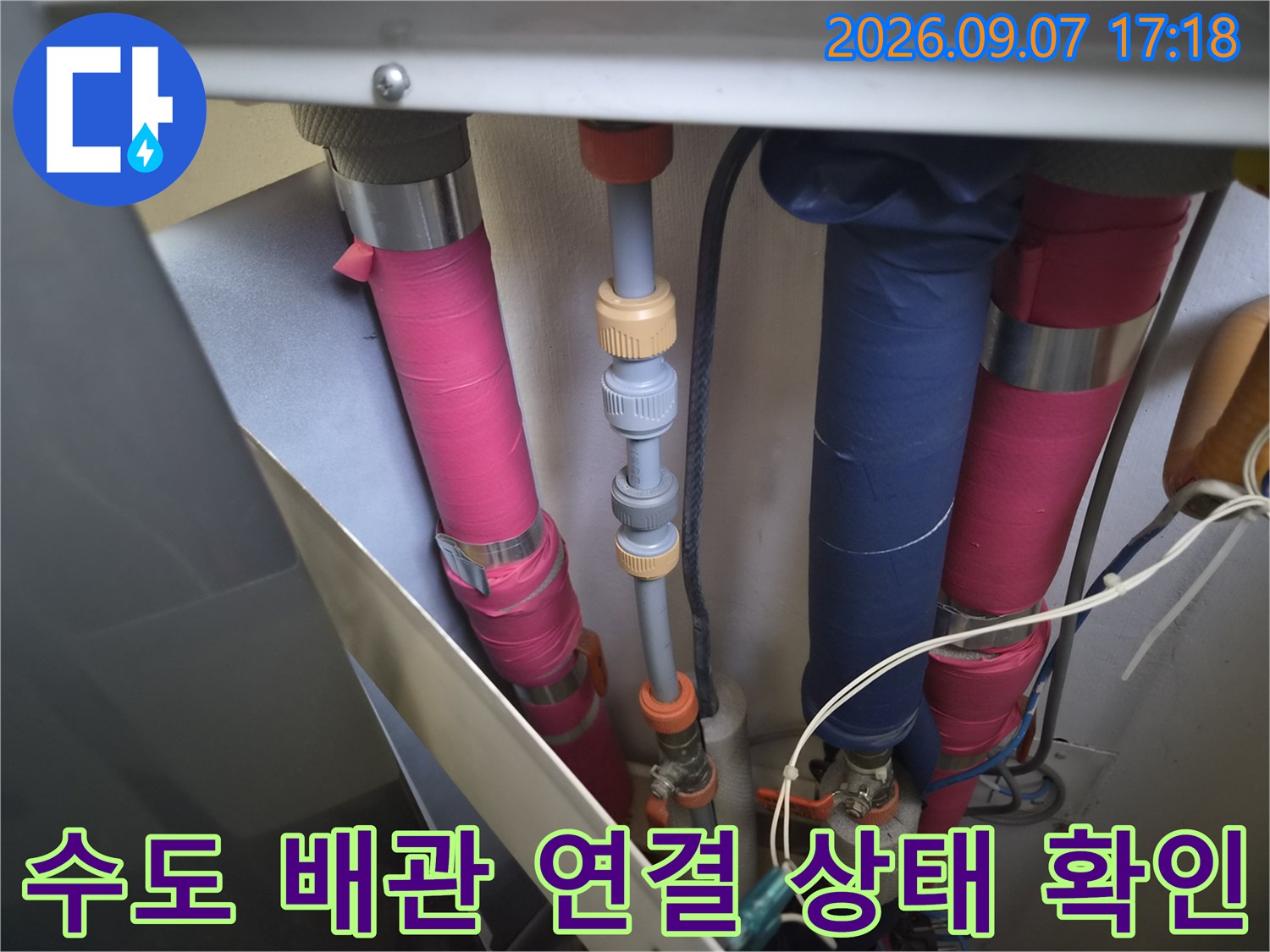 분홍색과 파란색 배관이 복잡하게 얽힌 욕실 하부 점검 상황