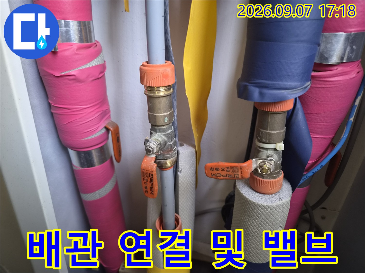 색상이 있는 보온재와-금속 소재의 밸브가 설치된 배관 모습입니다.