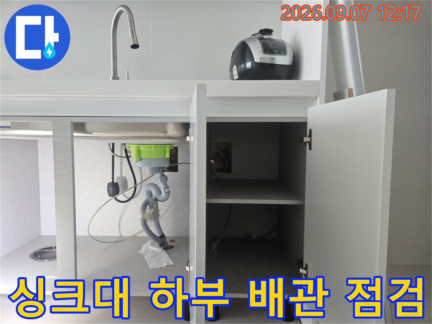 싱크대-하단-장 내부의-복잡한-배관과-호스-연결-상태