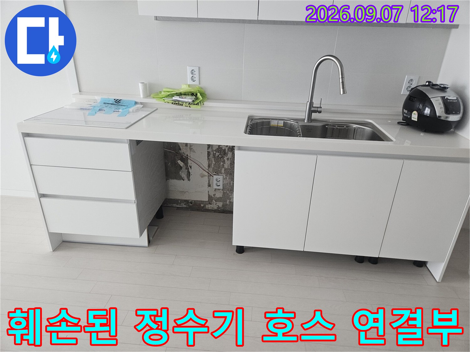 싱크대 하부장 내부의 훼손되어 물이 새는 배관 연결 부위 상세 사진