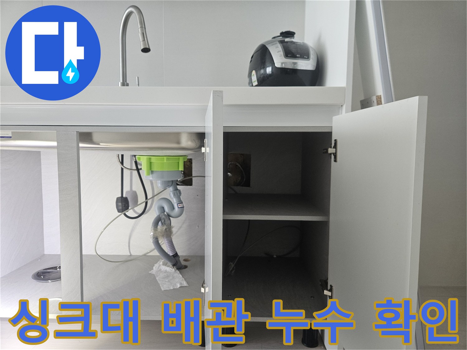 주방 싱크대 하부장 내부 - 정수기 호스 연결 부위 점검 중
