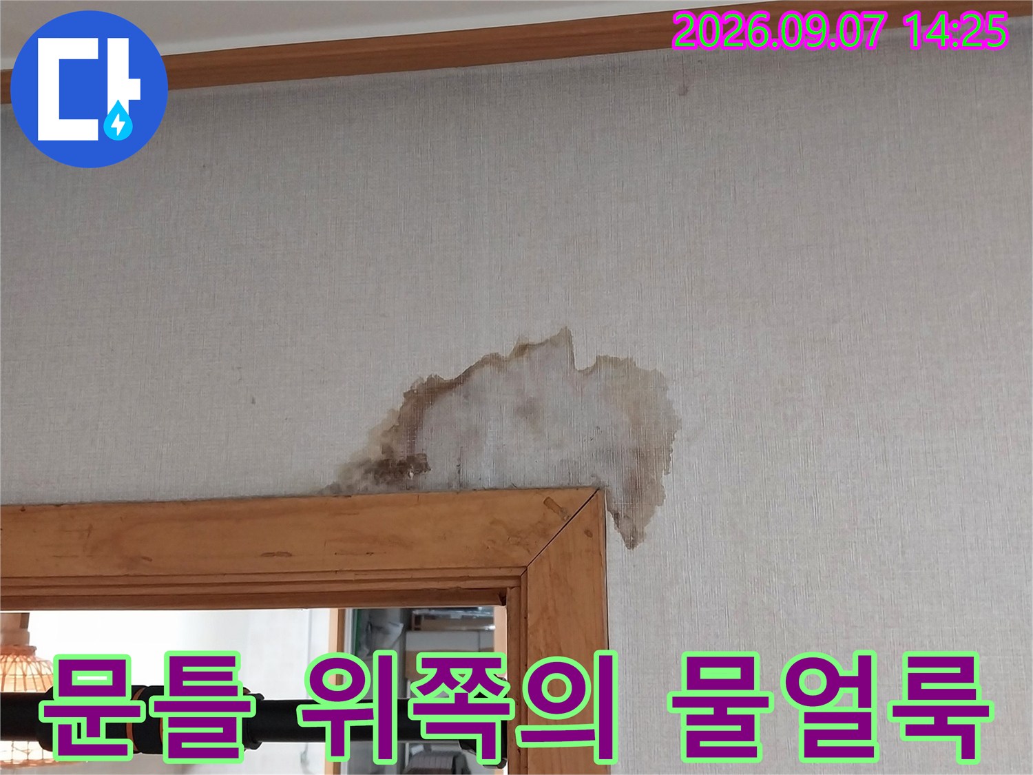 문틀 상단부 벽지가 젖어 얼룩진 현장 모습입니다.