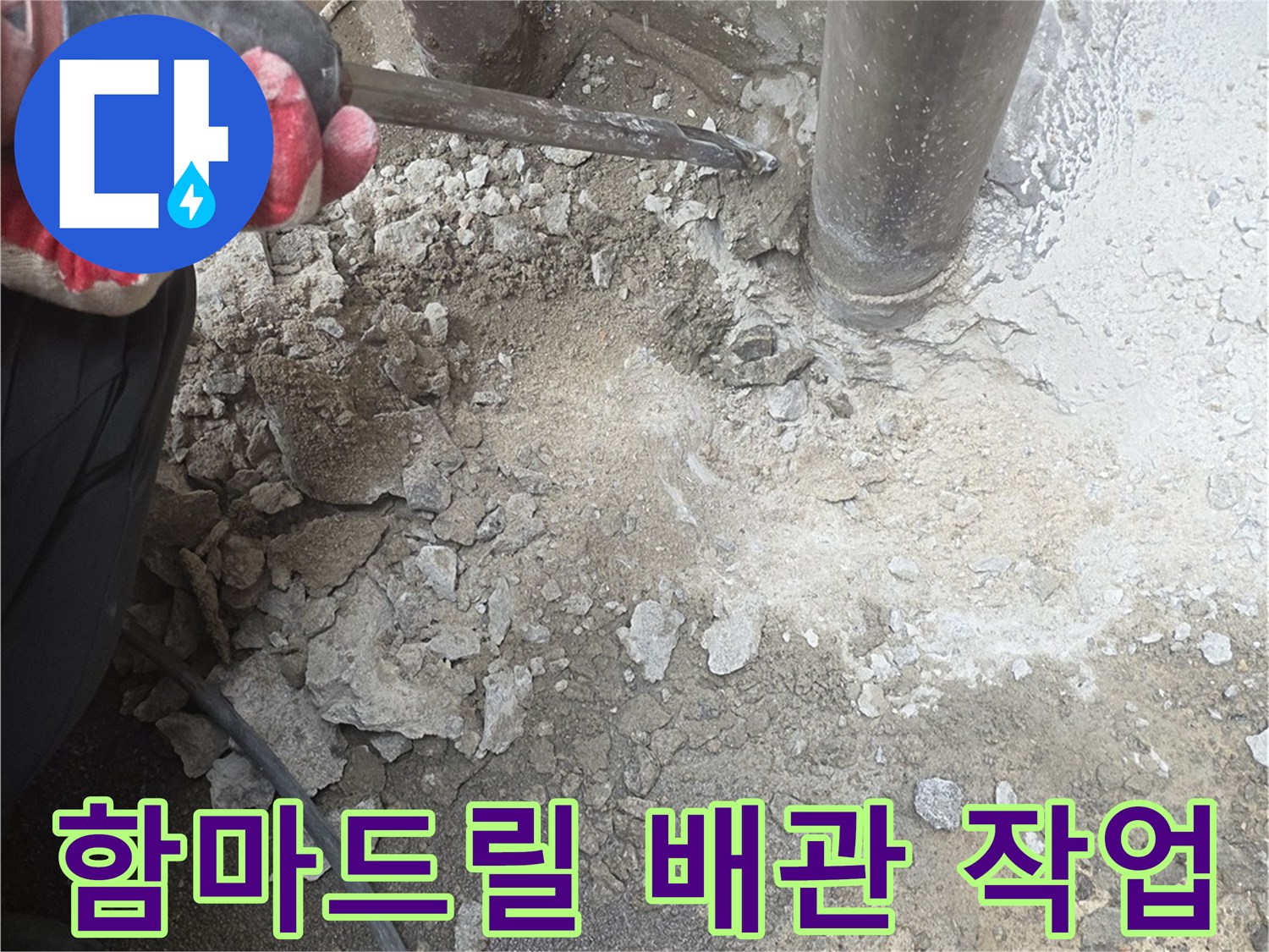 함마드릴을 사용하여 하수관 주변의 콘크리트 층을 제거하는 장면입니다.