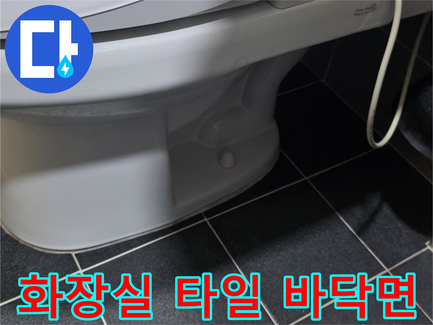 변기 옆 검은색 타일과 변기 하단부의 모습입니다.