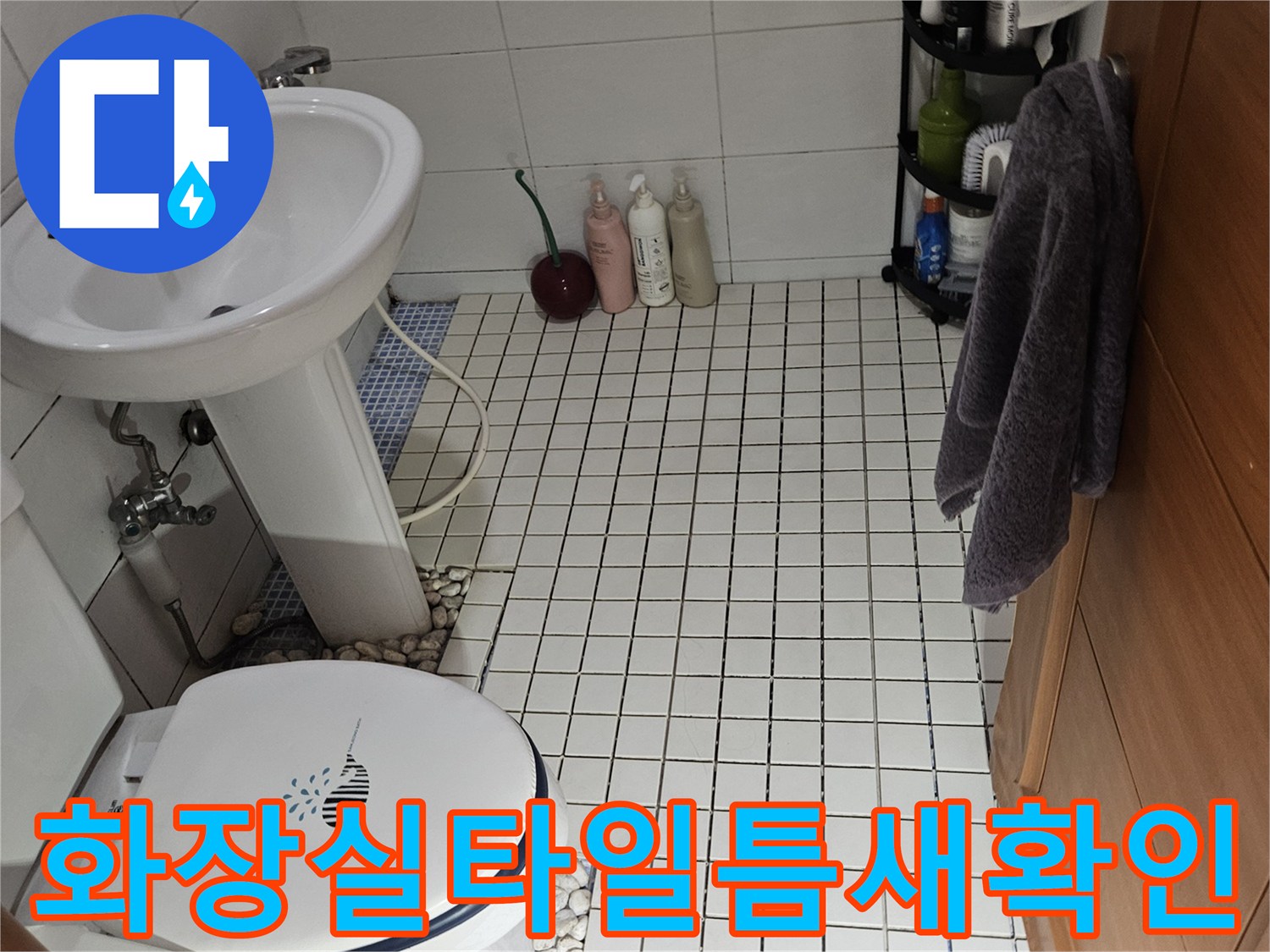 변기 주변 배관과 타일 사이의 습기 상태를 점검하는 장면