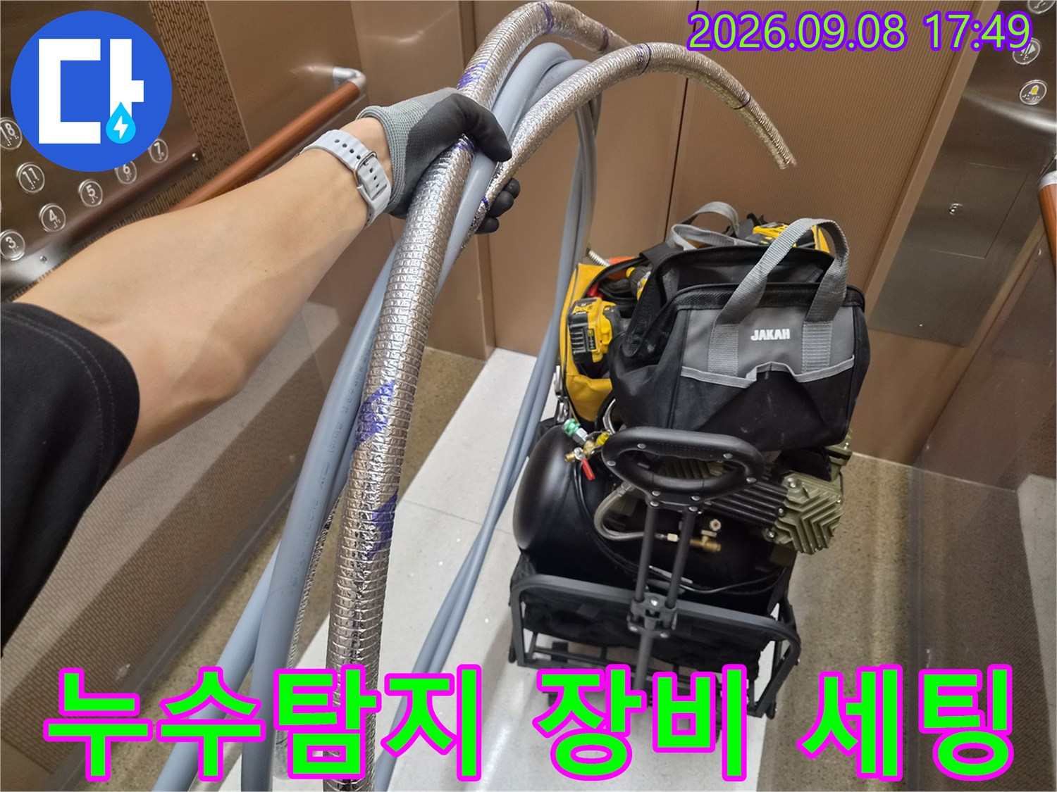 누수 탐지를 위해 준비된 공압 테스트용 호스와 전문 장비가 엘리베이터 안에 있습니다.