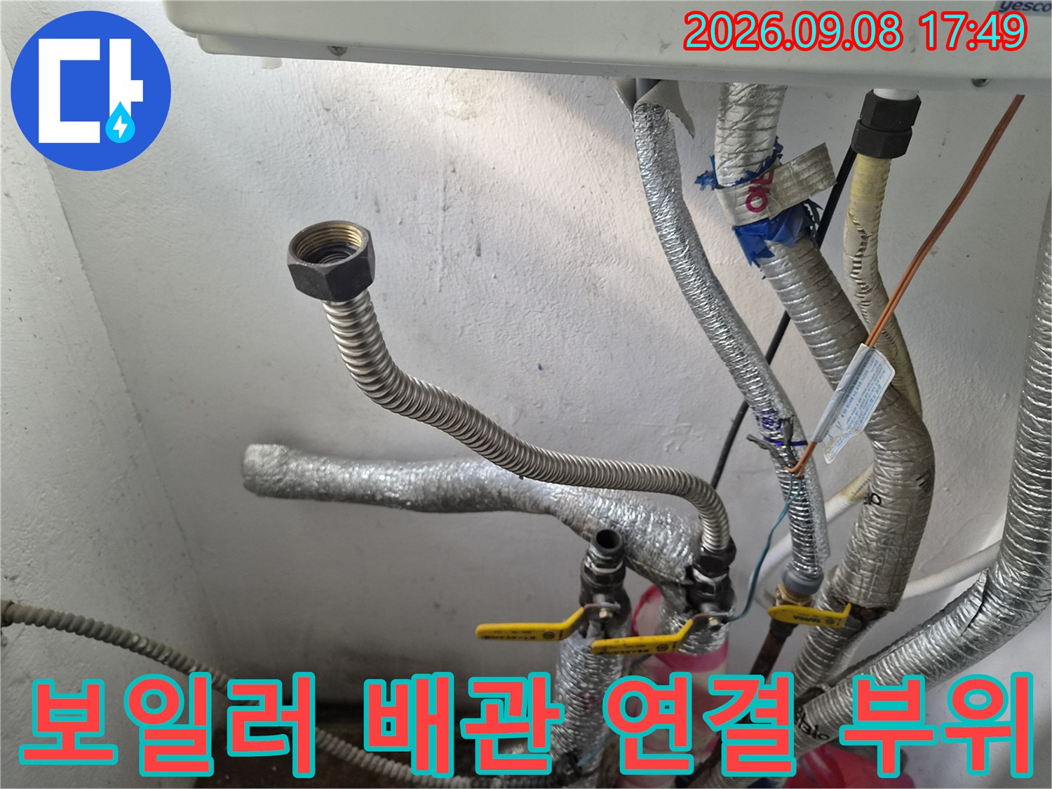 보일러 하단-은박 보온재로 감싸진 배관과 밸브 연결 상태