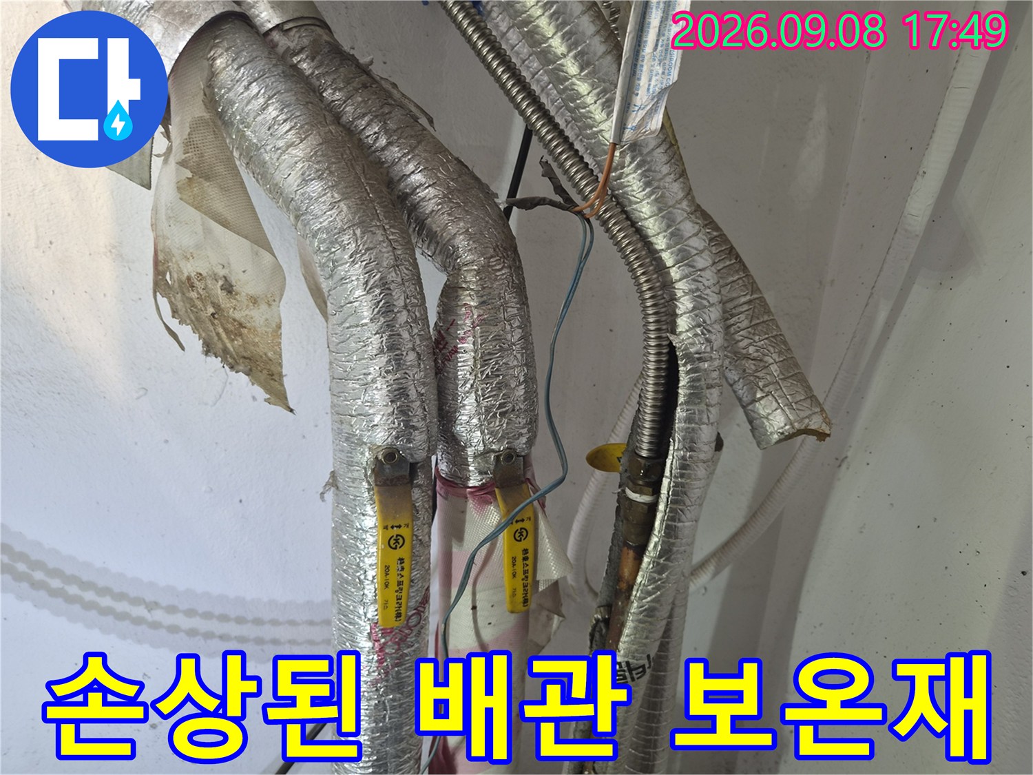 찢어진 은박 보온재 사이로 보이는 노후된 배선과 배관