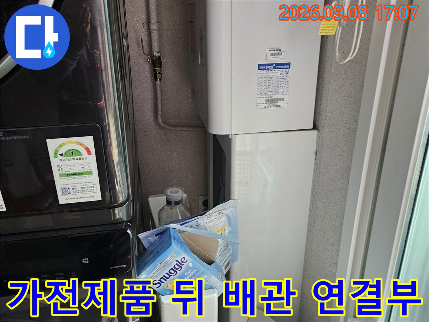 세탁기와 선반 사이의 수도 배관 및 주변 환경 사진입니다.