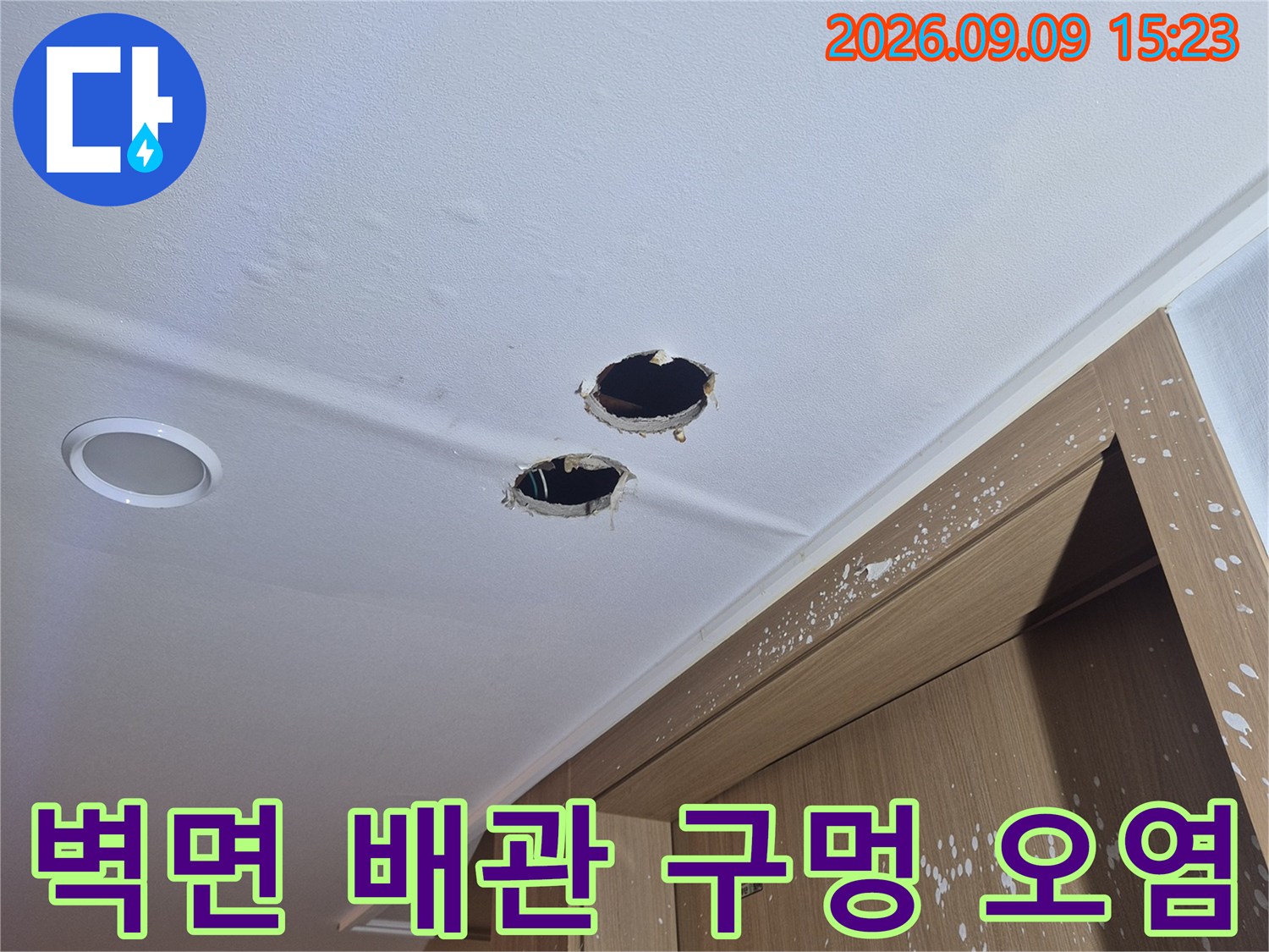 배관이 노출된 벽면 구멍 주변의 습기와 오염 상태를 촬영한 사진입니다.