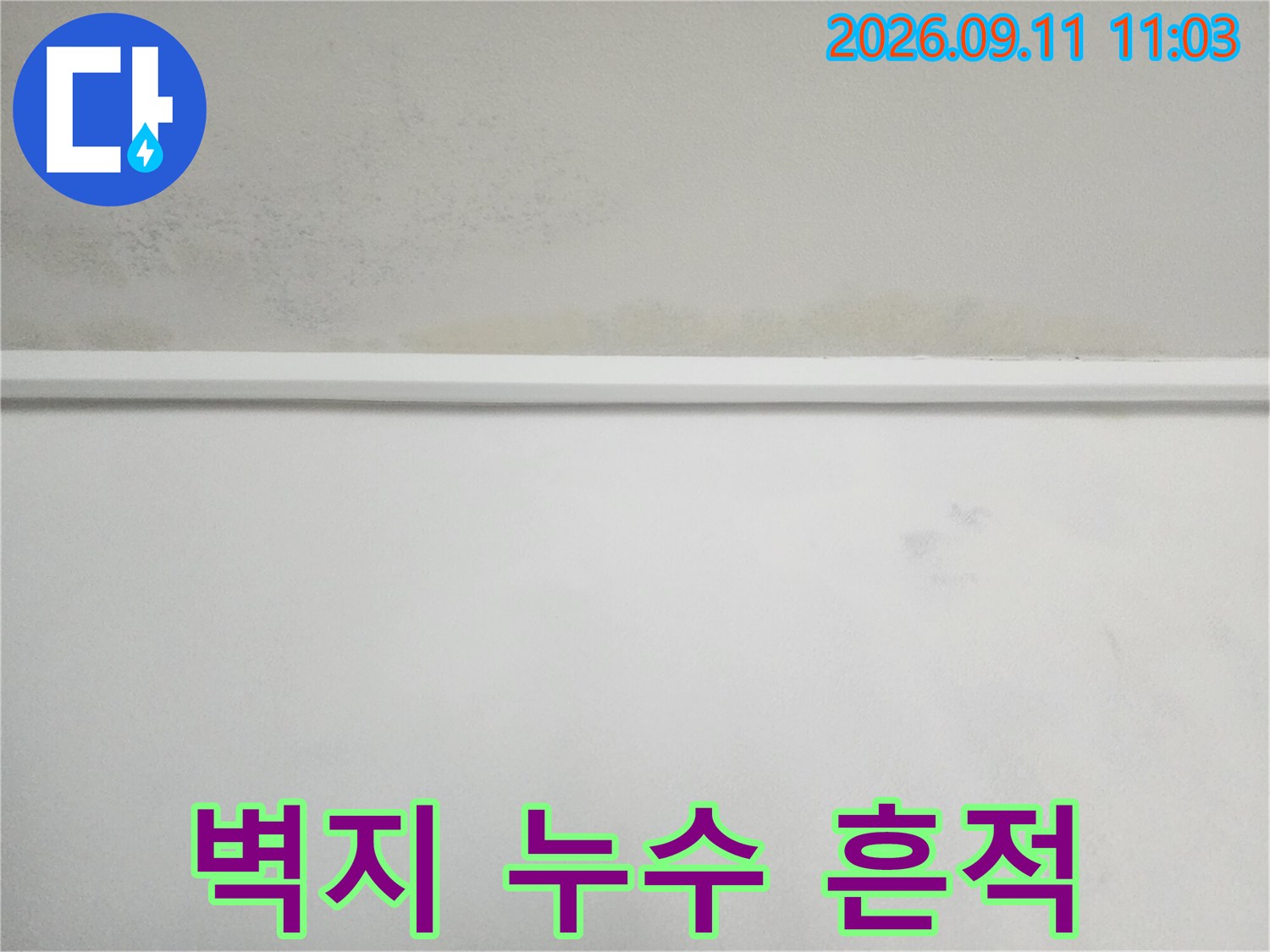 천장 상단 벽지에 나타난 습기 침투 및 변색된 부위