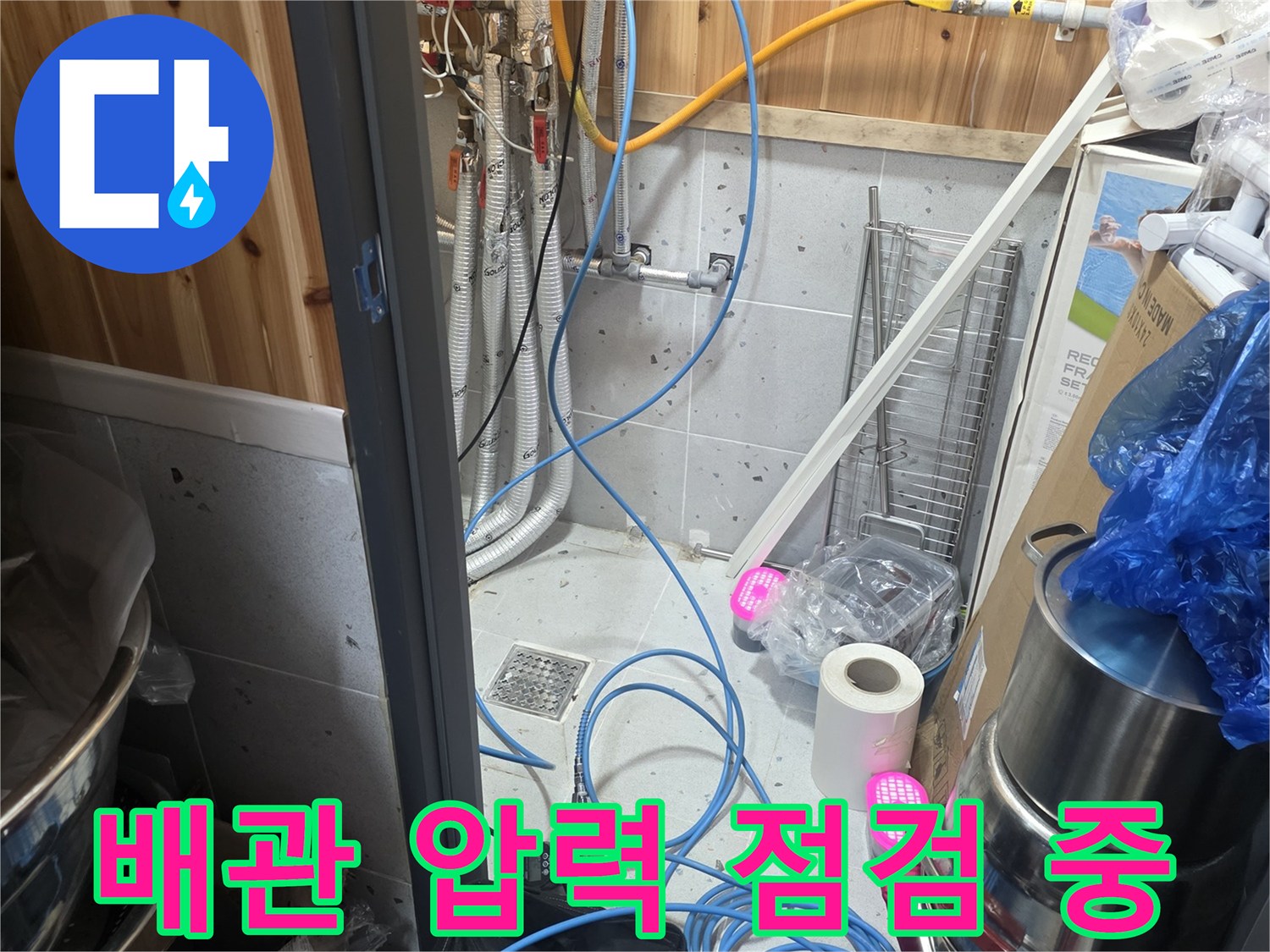 가스 탐지 장비와 파란색 호스가 연결된 배관 점검 모습