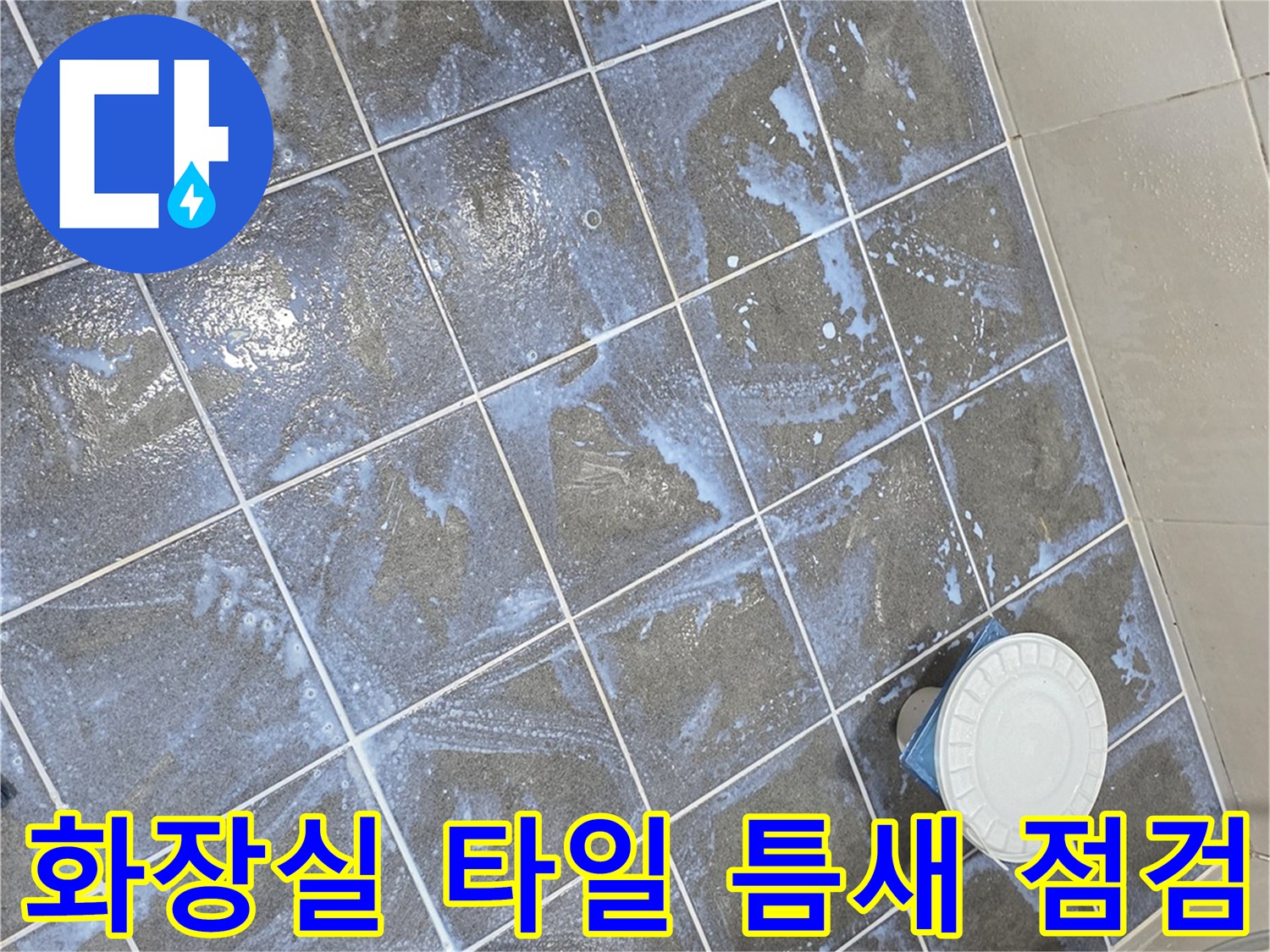 어두운 색상의 욕실 타일과 배수구 주변의 모습