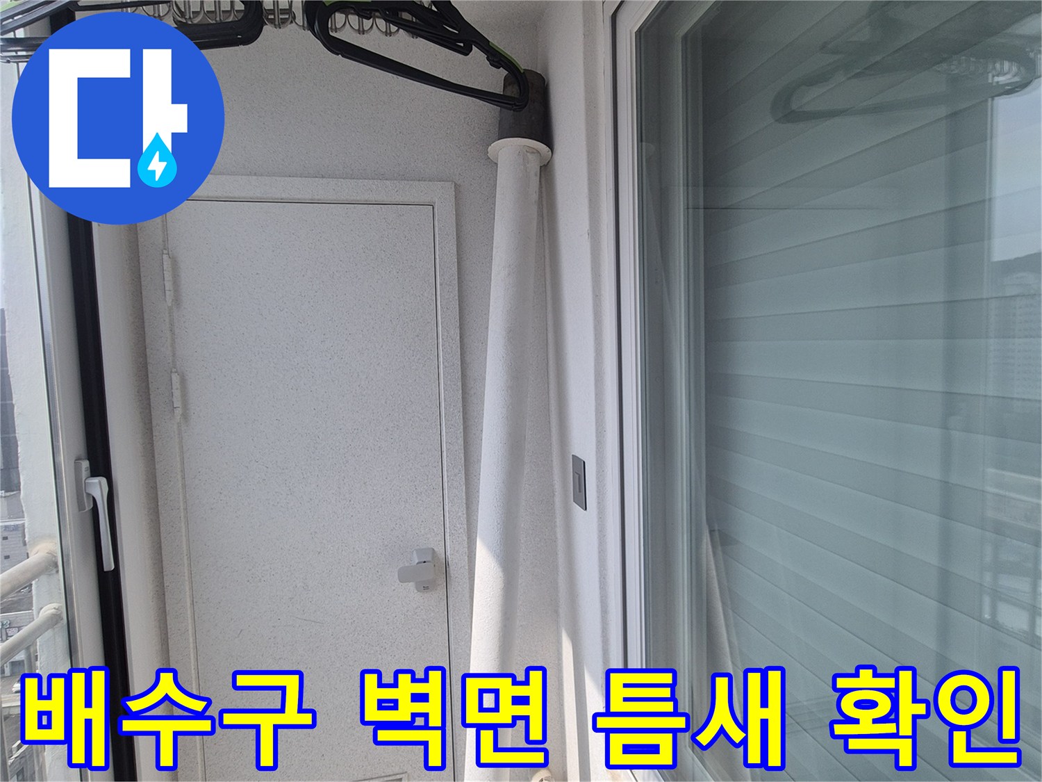 벽면에 설치된 배수관 주변의 벌어진 틈을 촬영한 사진입니다.