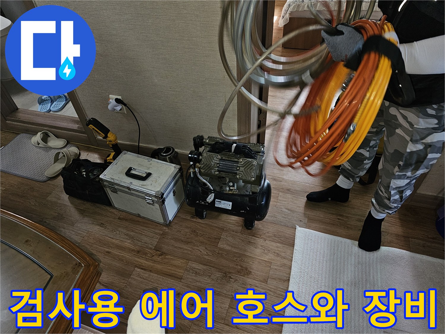 누수 탐지 작업을 위해 바닥에 놓인 검사용 호스 뭉치와 케이스