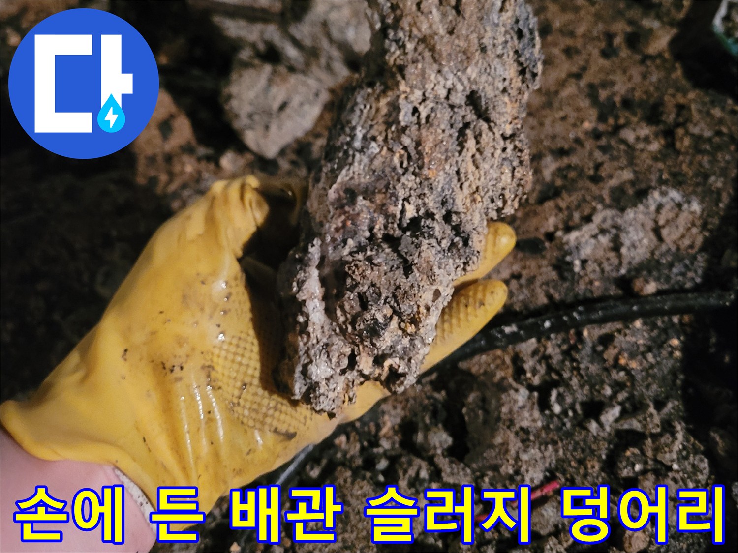 노란색 작업 장갑이 들고 있는 거친 질감의 슬러지